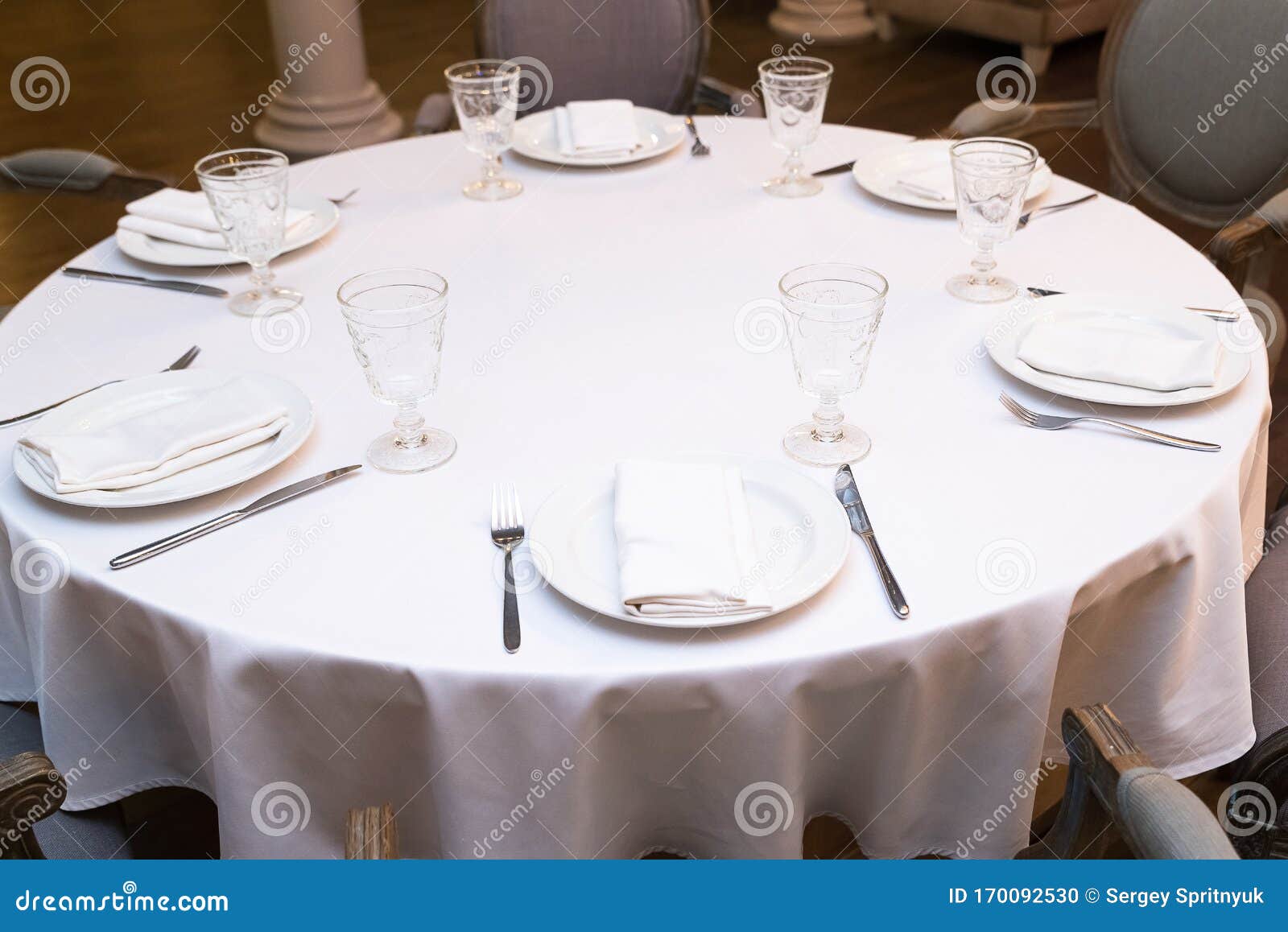 Enjoy a Round Dining Table with White Tablecloth in the Restaurant