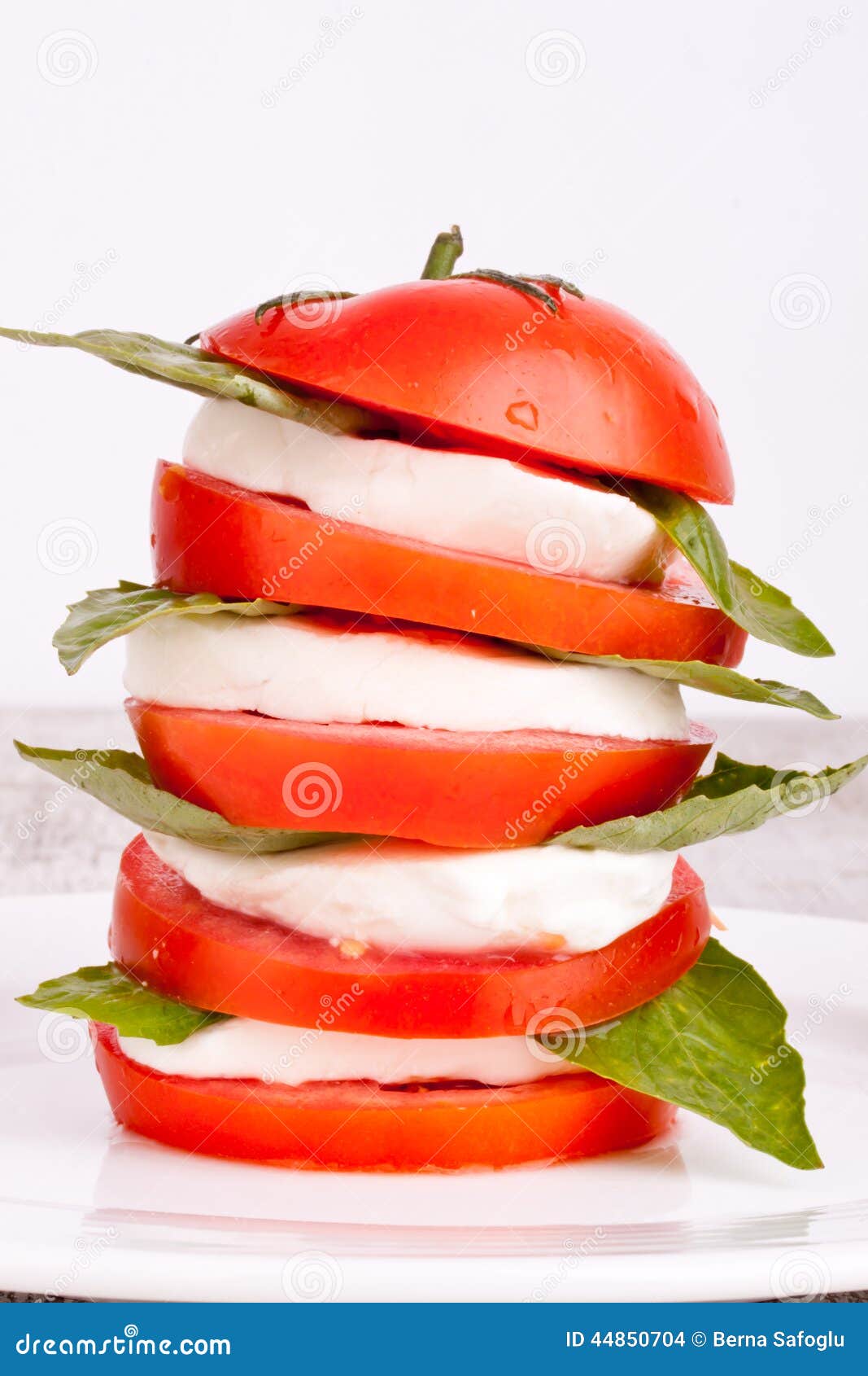 Ensalada de Caprese con la mozarela, el tomate y la albahaca. Ensalada de Caprese con la mozzarella, el tomate y la albahaca en un fondo blanco