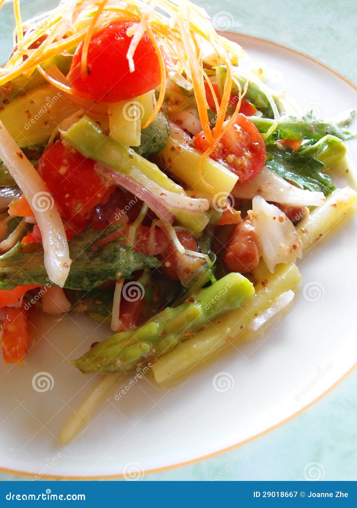 Ensalada vegetariana del espárrago. Una fotografía que muestra una placa de la ensalada orgánica fresca y de restauración de las verduras, incluye los tallos del espárrago, tomates, cohetes salvajes, cebollas, zanahorias, y asperjado con las hierbas sobre una salsa ligera del aceite y del vinagre de oliva. Tomado en el restaurante exclusivo de la prioridad de la salud, donde están sobre todo orgánicos o con poca grasa e inferiores los ingredientes usados en el contenido en sal. Veggies orgánico producidos deliciosos y sabrosos. Arrancador gastrónomo vegetariano sano de la cocina. Fotografía de cena fina en la configuración de la luz del día natural. Imagen del formato vertical, nadie en imagen.