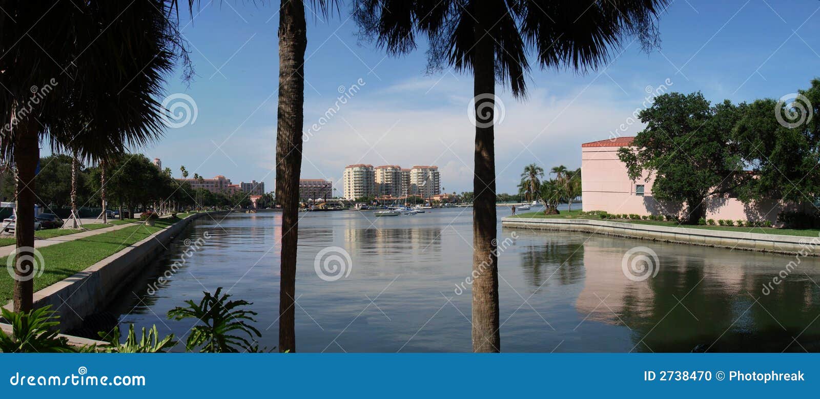 Entrada tropical panorâmico. Uma vista panorâmico tropical de uma entrada no oceano com as palmas nos edifícios da parte dianteira e da cidade no fundo.