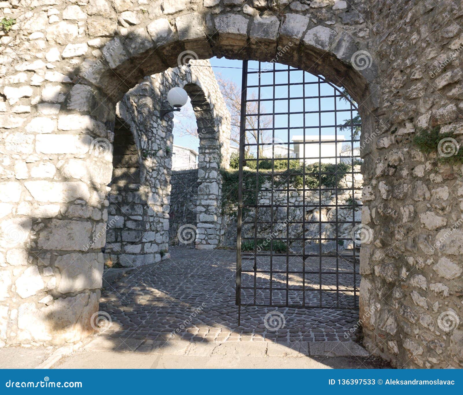 Entrada vieja antigua de la piedra del castillo con la puerta del hierro. Entrada de piedra vieja antigua con la puerta del hierro Puerta abierta a la entrada delantera al castillo
