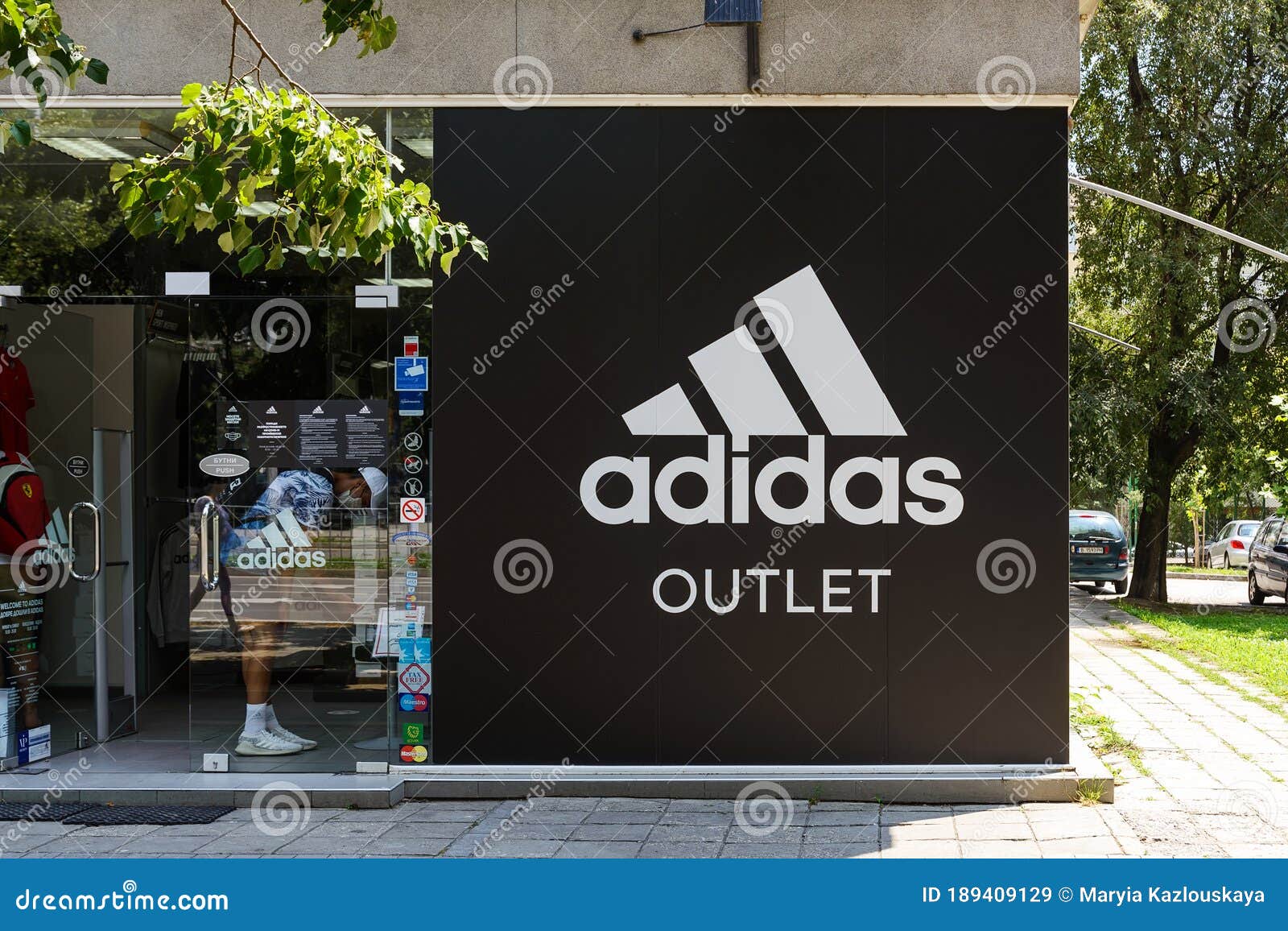 Entrance To Adidas Outlet Shop from a City Street on a Sunny Day. Signboard of Adidas Logo Brend Sign on Store, Boutique Stock Image - Image of clothing, 189409129