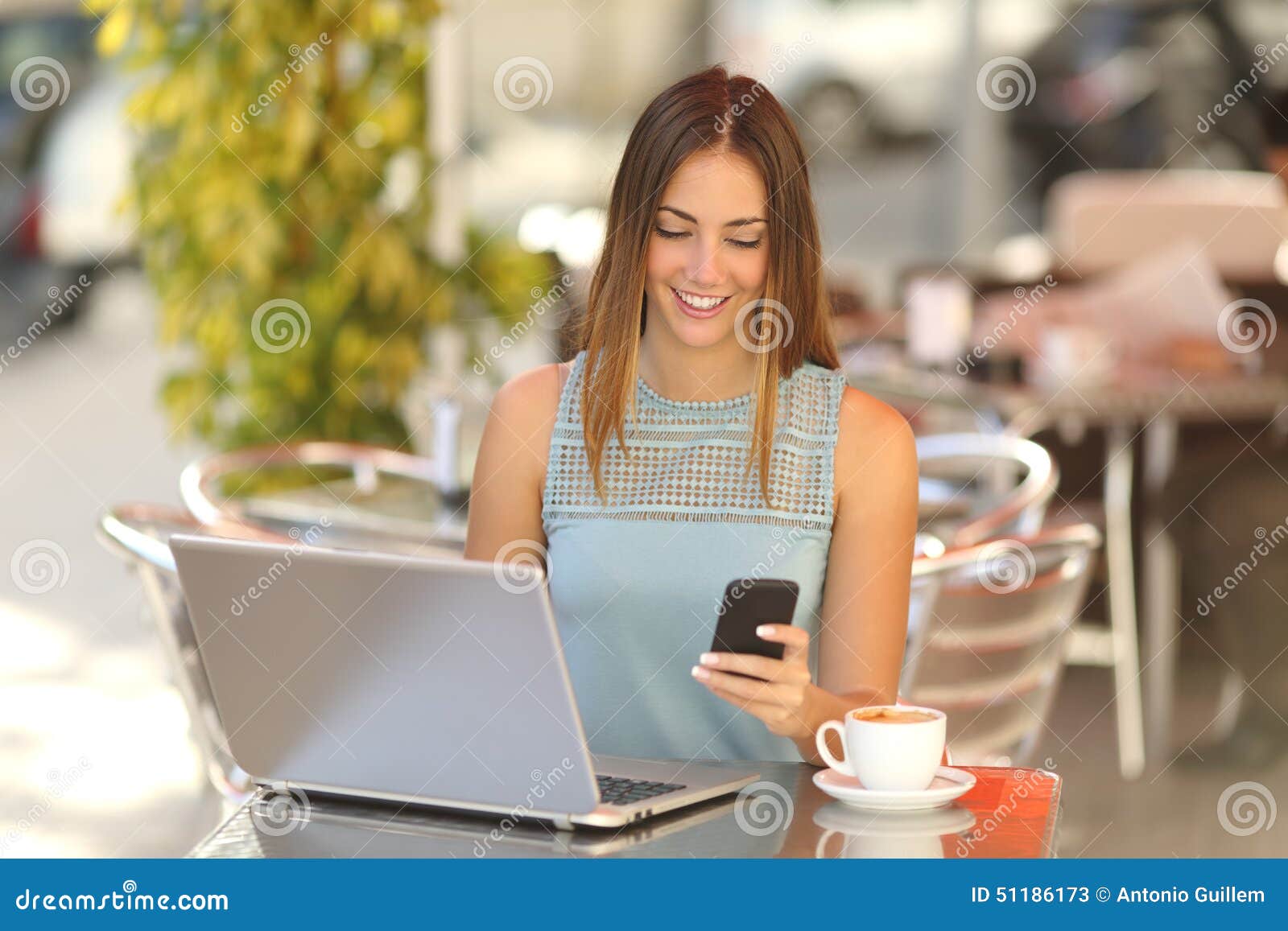 entrepreneur working with a phone and laptop in a coffee shop