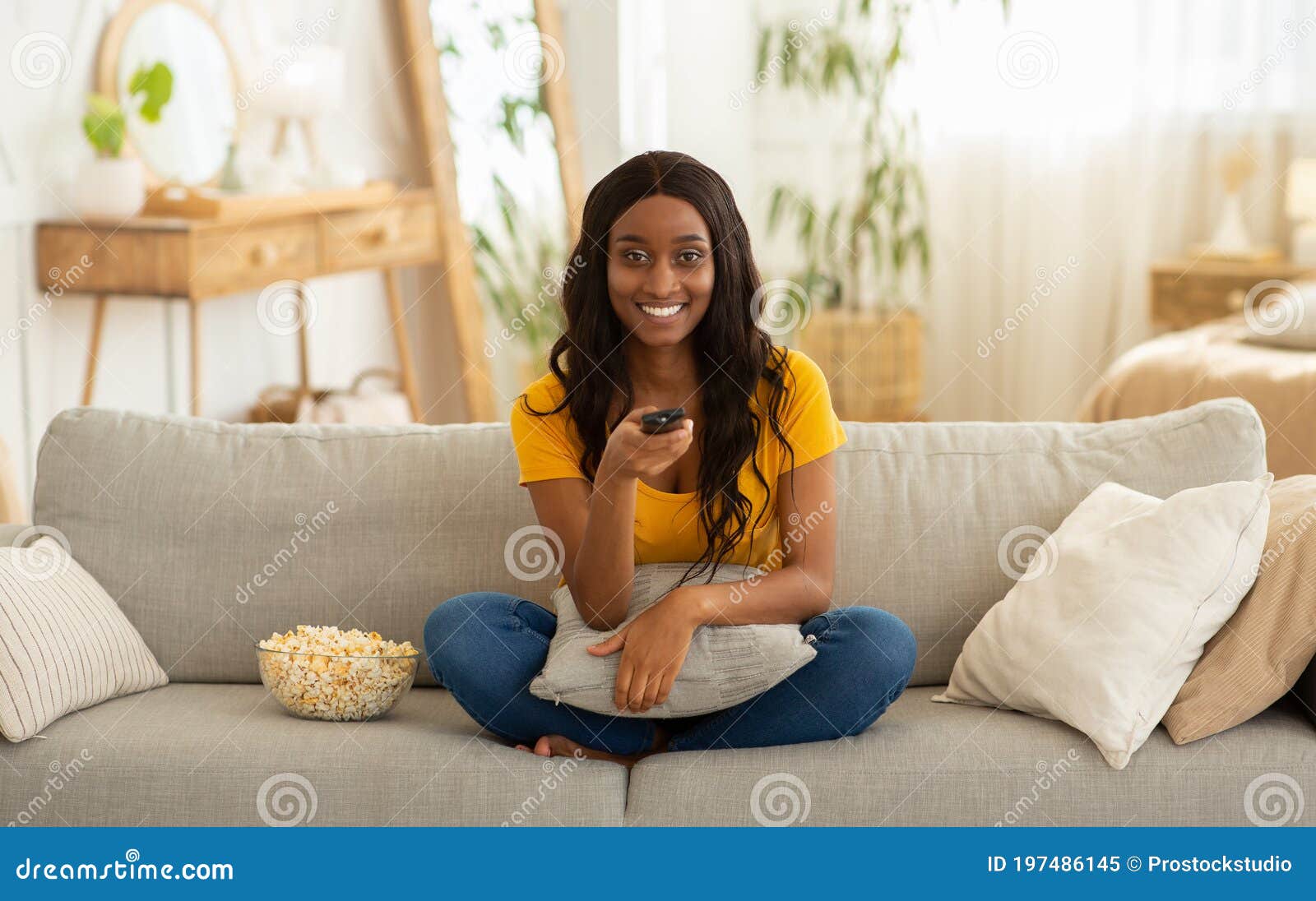 Sorridente menina deitada no sofá confortável, gostando de jogar