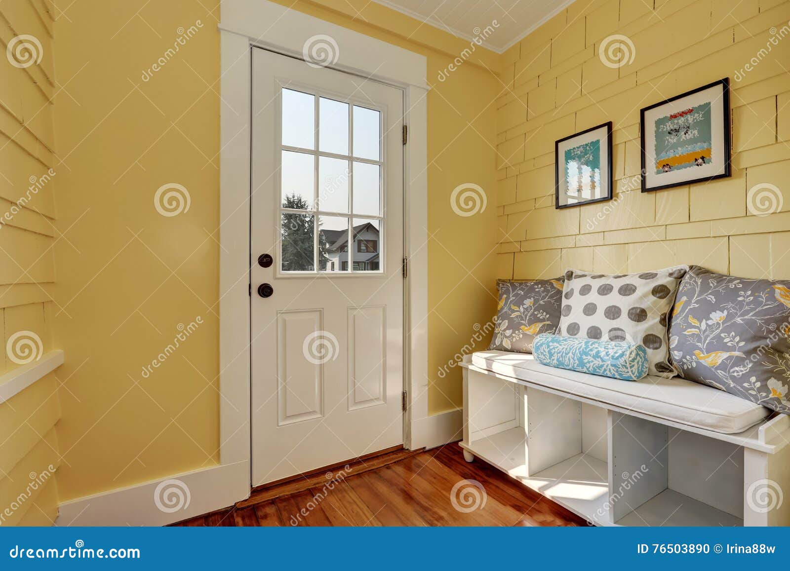 entryway with yellow walls and storage bench in white