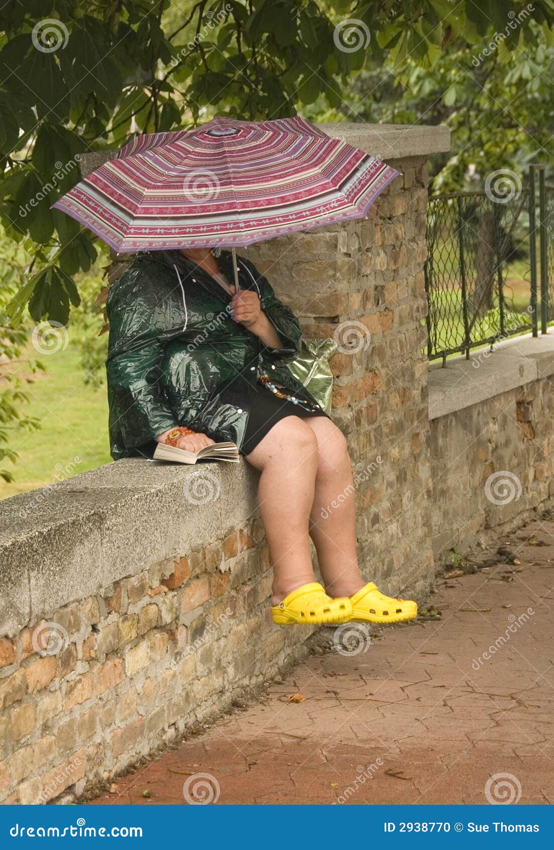 Entspannung im Regen. Person, die im Regen sich entspannt und ihr Buch liest