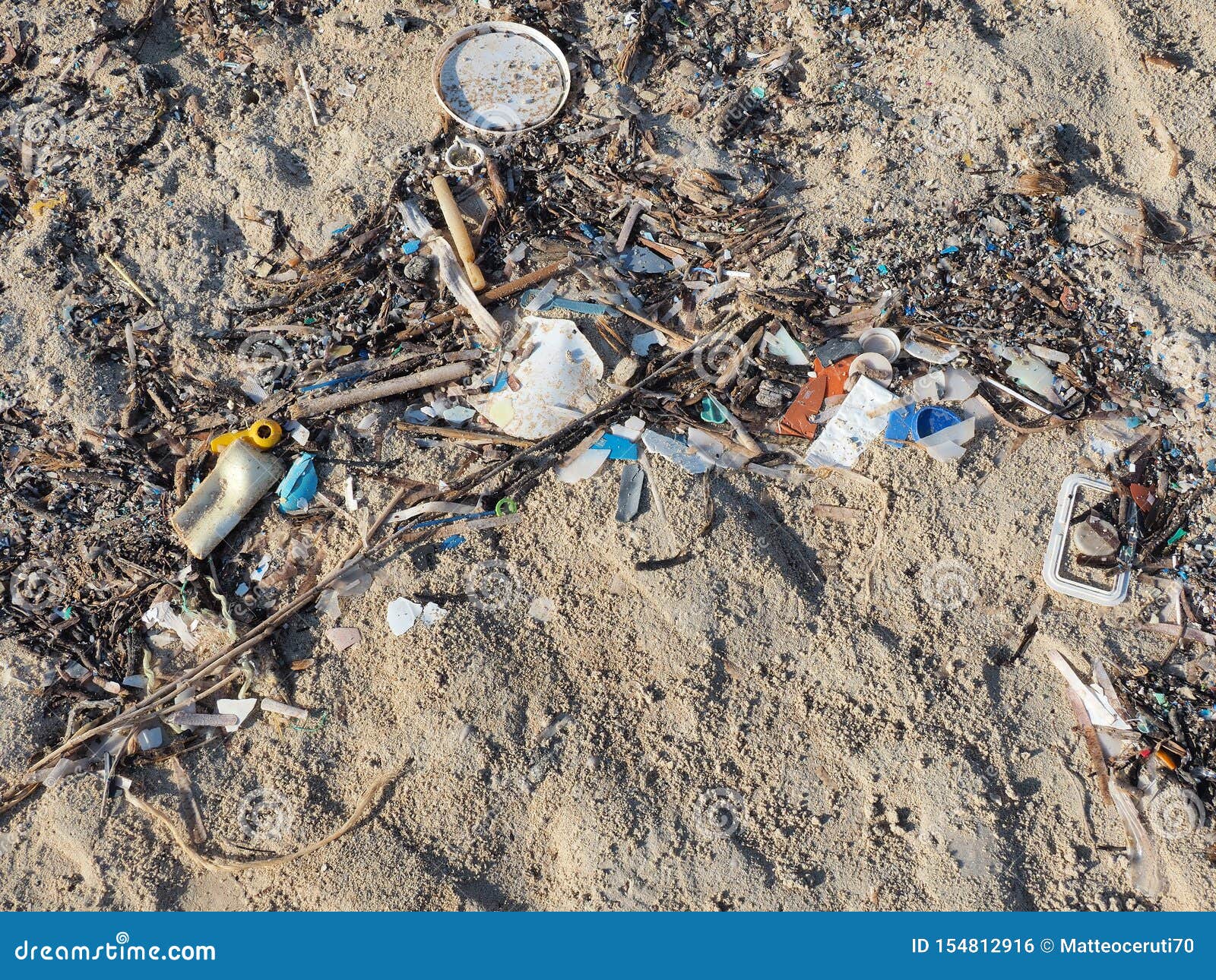 Environmental Pollution. Sand Beaches Polluted with Pieces of Plastic