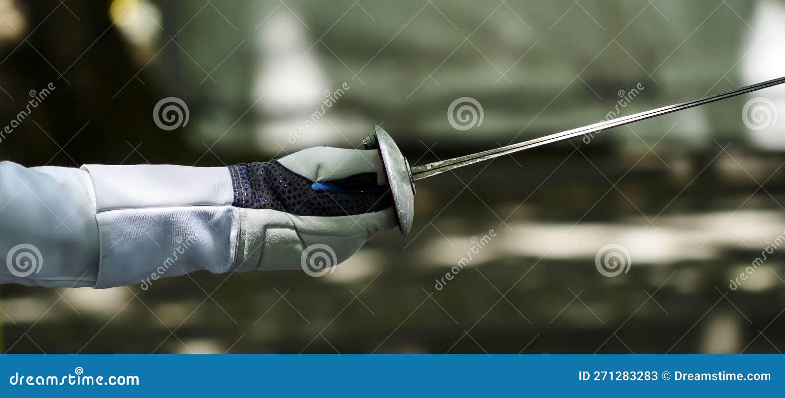 epee of fencer with protected hand and arm against blurred background