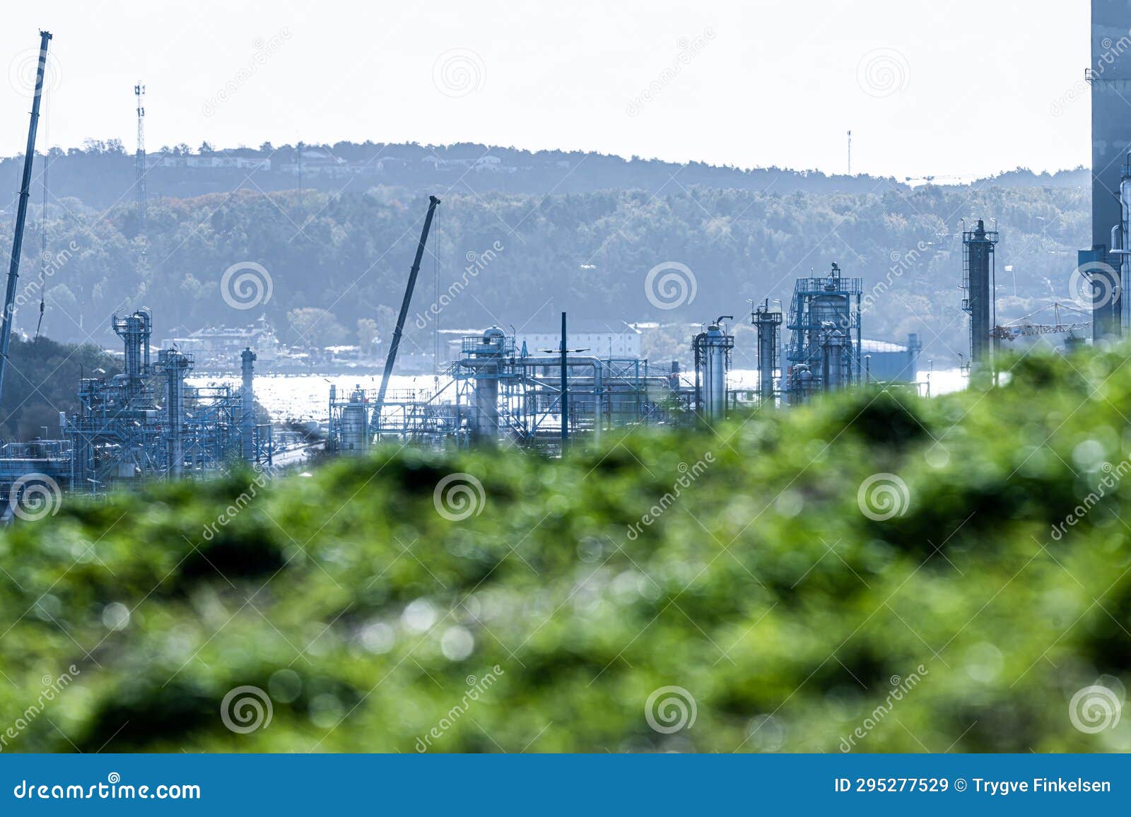 Equipment at an Oil Refinery Behind Grass Hill.. Stock Image Image of