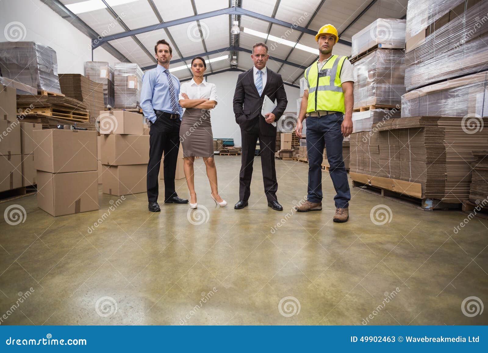 Equipo De Warehouse Que Se Coloca De Mirada De La Cámara Imagen de archivo Imagen de brazos