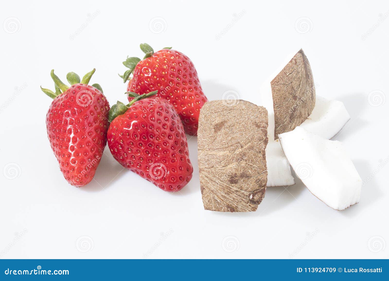 Erdbeeren und Kokosnusszusammensetzung in einem weißen Hintergrund. Erdbeeren und Kokosnuss in einer weißen Hintergrundzusammensetzung