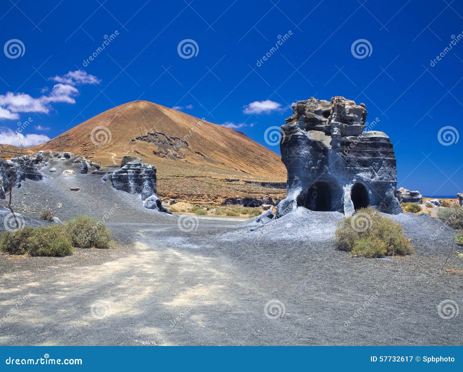 erosion weathering blue rock formations plano de el mojon against the background of a volcanic cone, blue sky