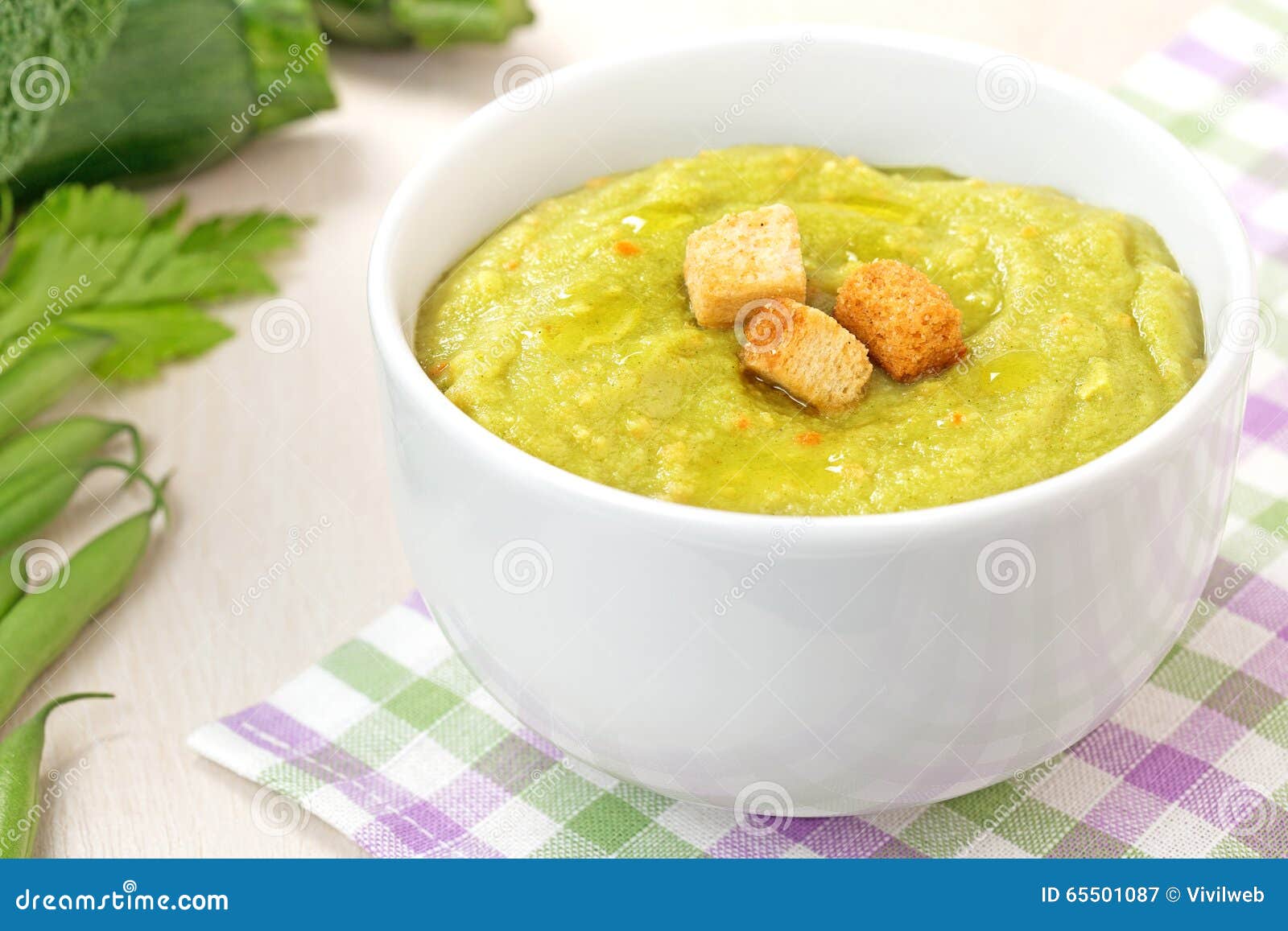 Erva-benta saudável com pão torrado. Sopa vegetal com o pão torrado no guardanapo quadriculado