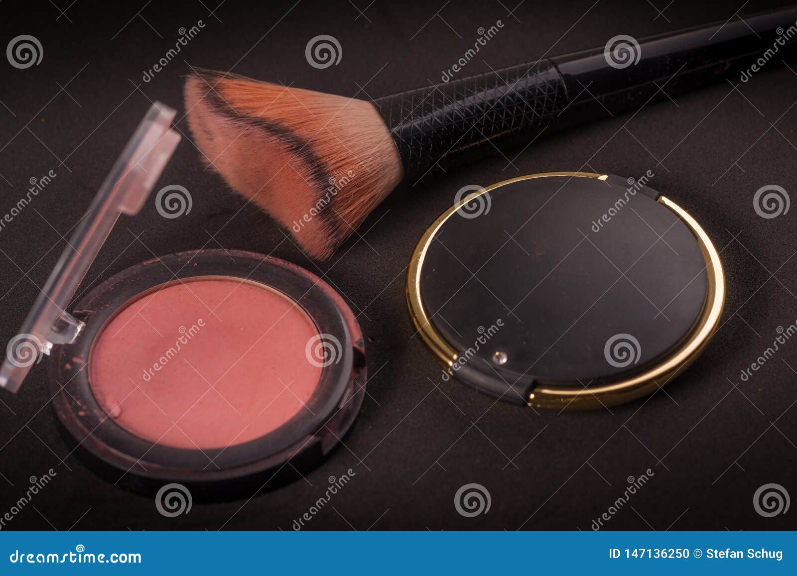 Escove, core e espelhe - o material fêmea da beleza. Uma escova da composição retratada com espelho e algum vermelho A imagem é composta em um contexto escuro