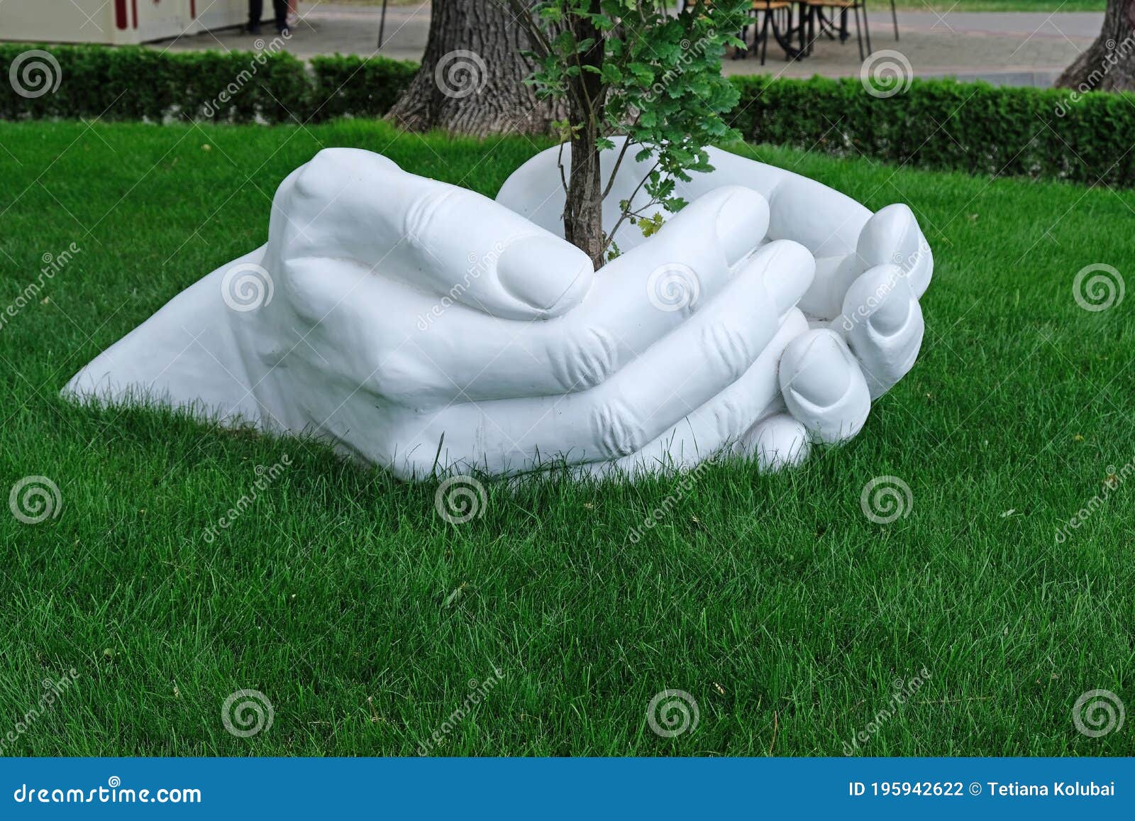 Escultura De Una Mano Hecha De Yeso Sobre Un Fondo De Césped Verde