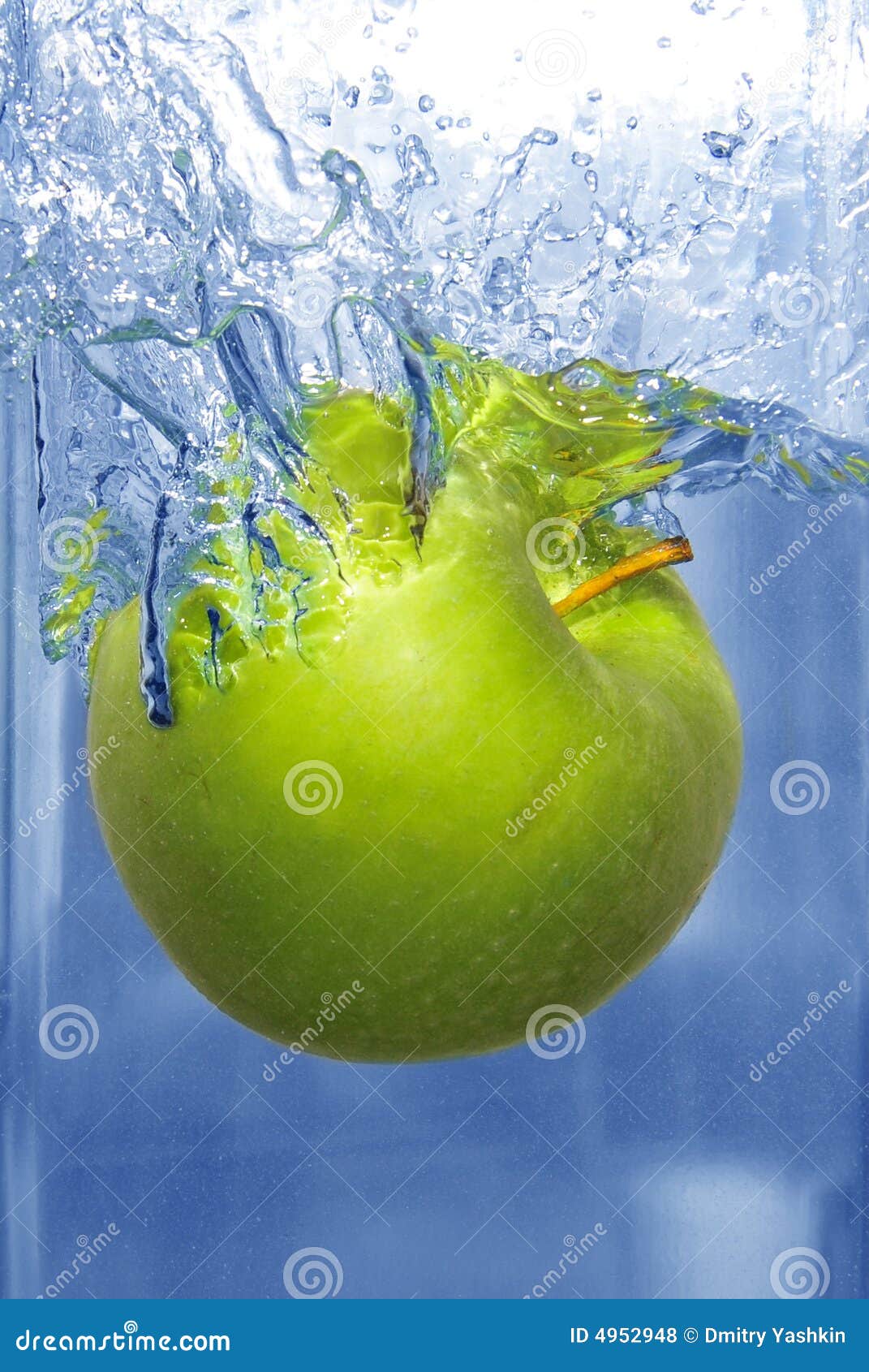 Espirrando a maçã em uma água azul