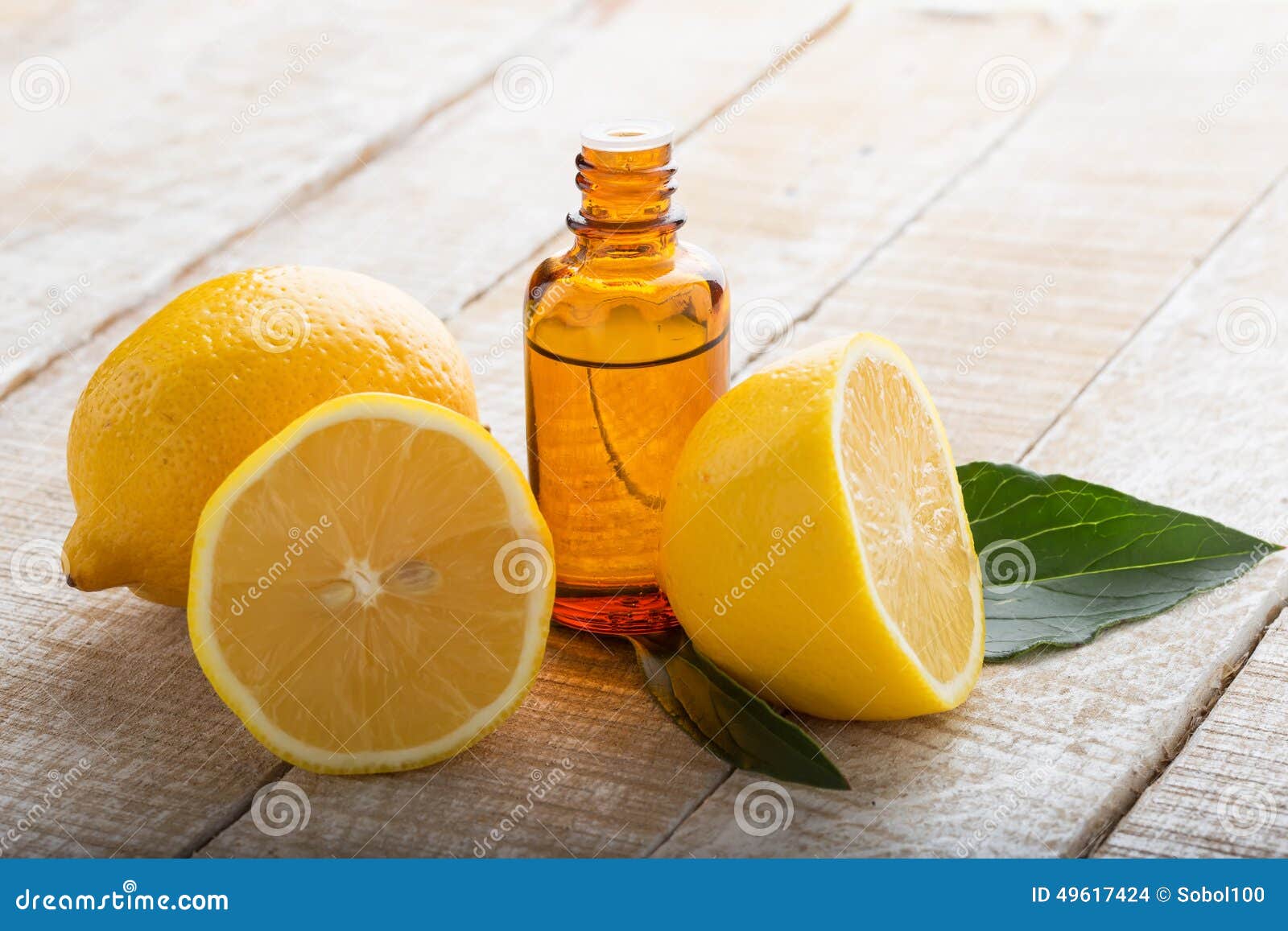 Essential aroma oil with lemon on wooden background. Selective focus.