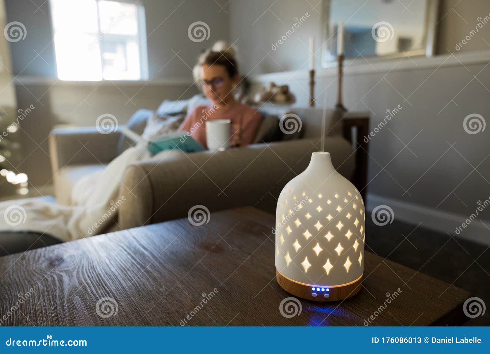 essential oil diffuser with a young woman relaxing in the background