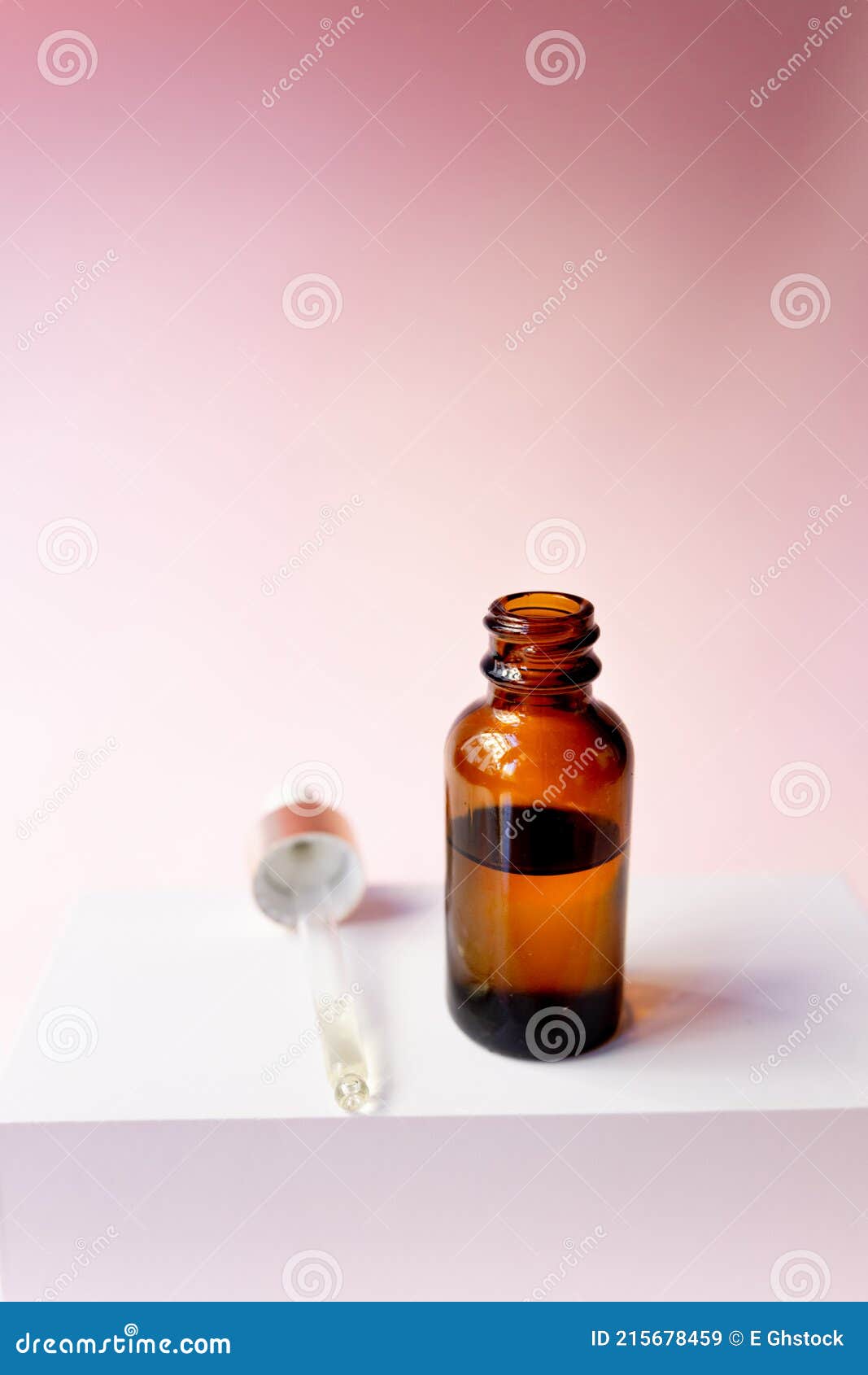 essential oil serum glass pipette and bottle on pink background. natural serums. cosmetic concept