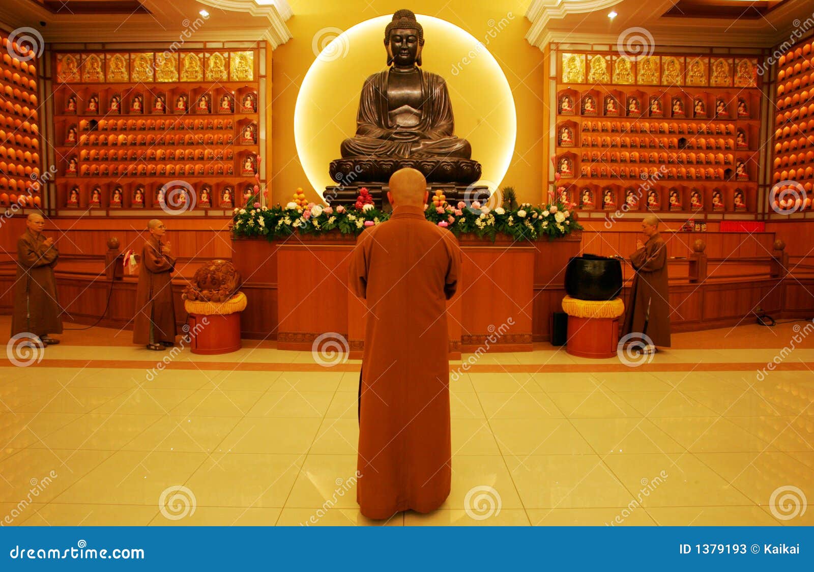 Un infront de rogación del devoto de una estatua de Buddha.