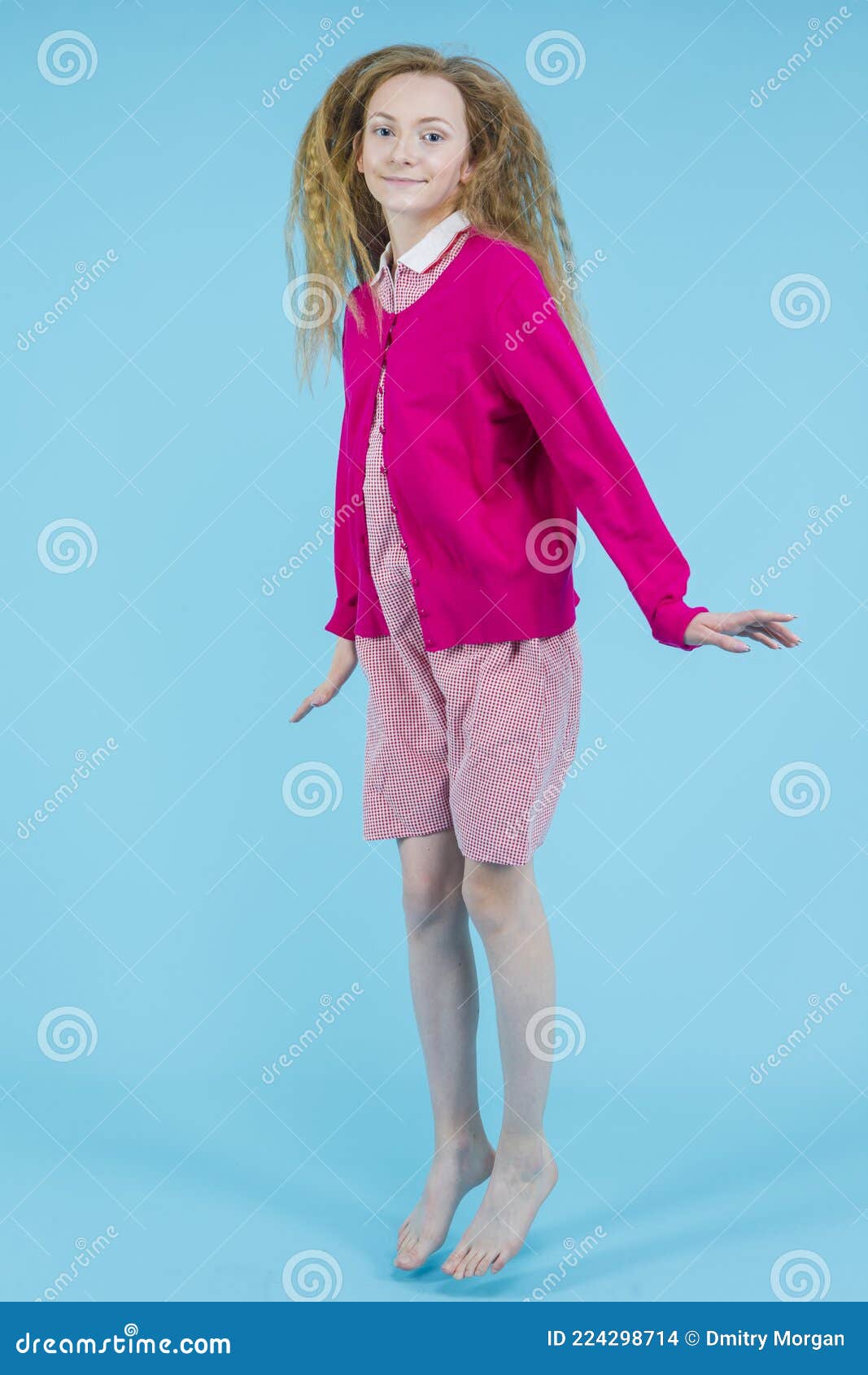 De Vida Adolescente. Adolescente Ativa Com Vestimenta Vermelha Vestida Com Jumper Rosa Movendo Contra Fundo Azul Foto de Stock - Imagem de azul, emocional: