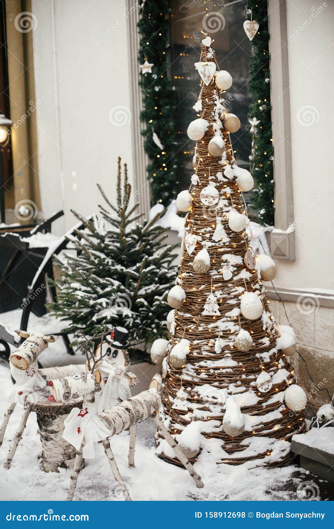 Estilosos Pasteles Renos De Madera Y Muñecas De Nieve En Un Rústico árbol De Navidad En El Mercado De Vacaciones En Una Calle D Foto de archivo - Imagen de vacaciones, pasteles: