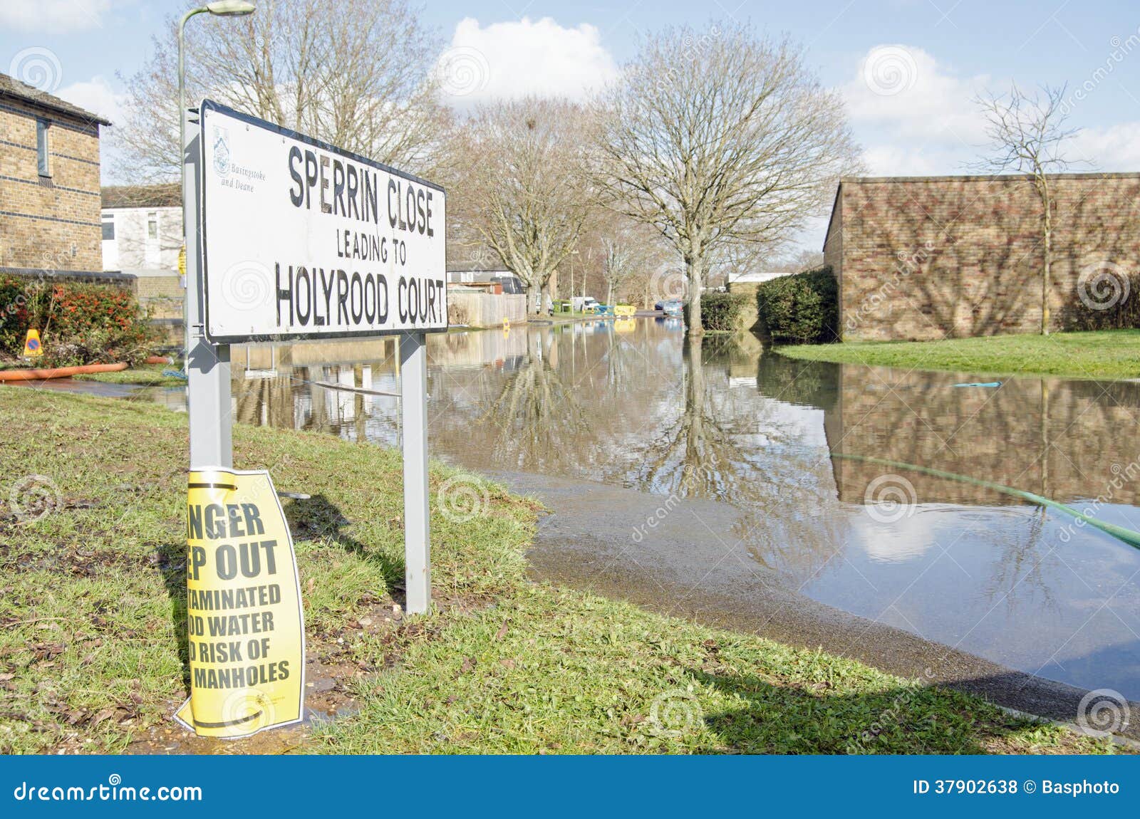 Estrada inundada, Basingstoke. BASINGSTOKE, INGLATERRA - 16 DE FEVEREIRO DE 2014: Uma estrada residencial inundou por águas subterrâneas após tempestades pesadas em Basingstoke, Hampshire.  Muitos residentes foram evacuados de suas casas.