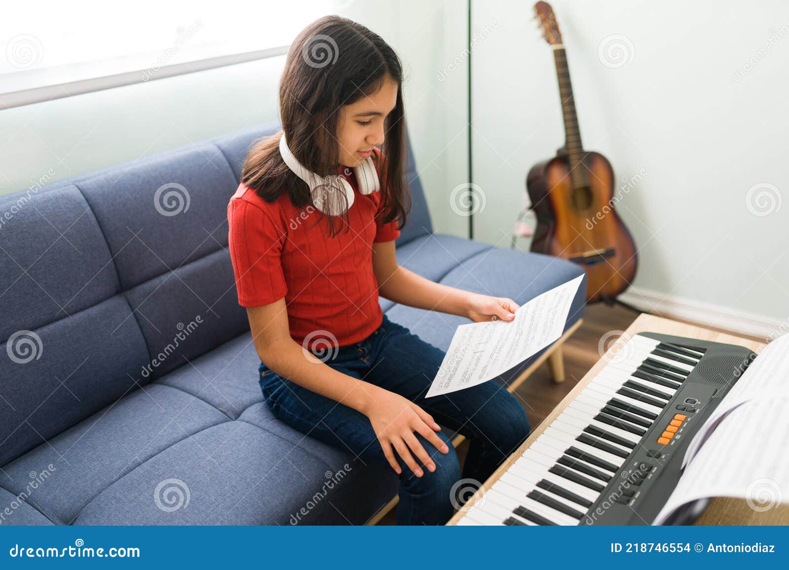 Menina aprende a tocar piano com música online para ensino à