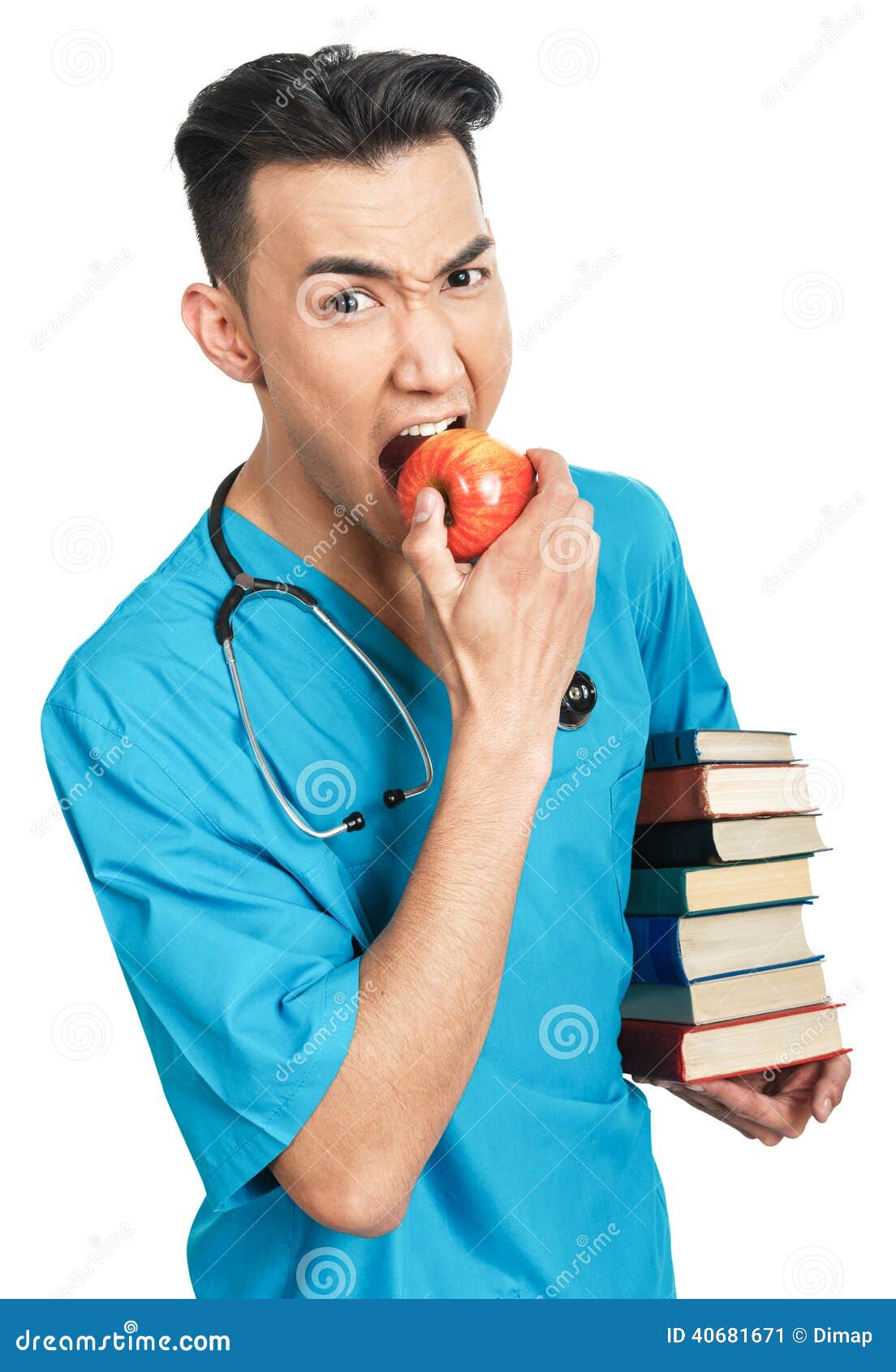 Estudante de Medicina com livros. Uma estudante de Medicina masculina séria nova (enfermeira, interno, doutor) com um grupo dos livros e de uma maçã vermelha