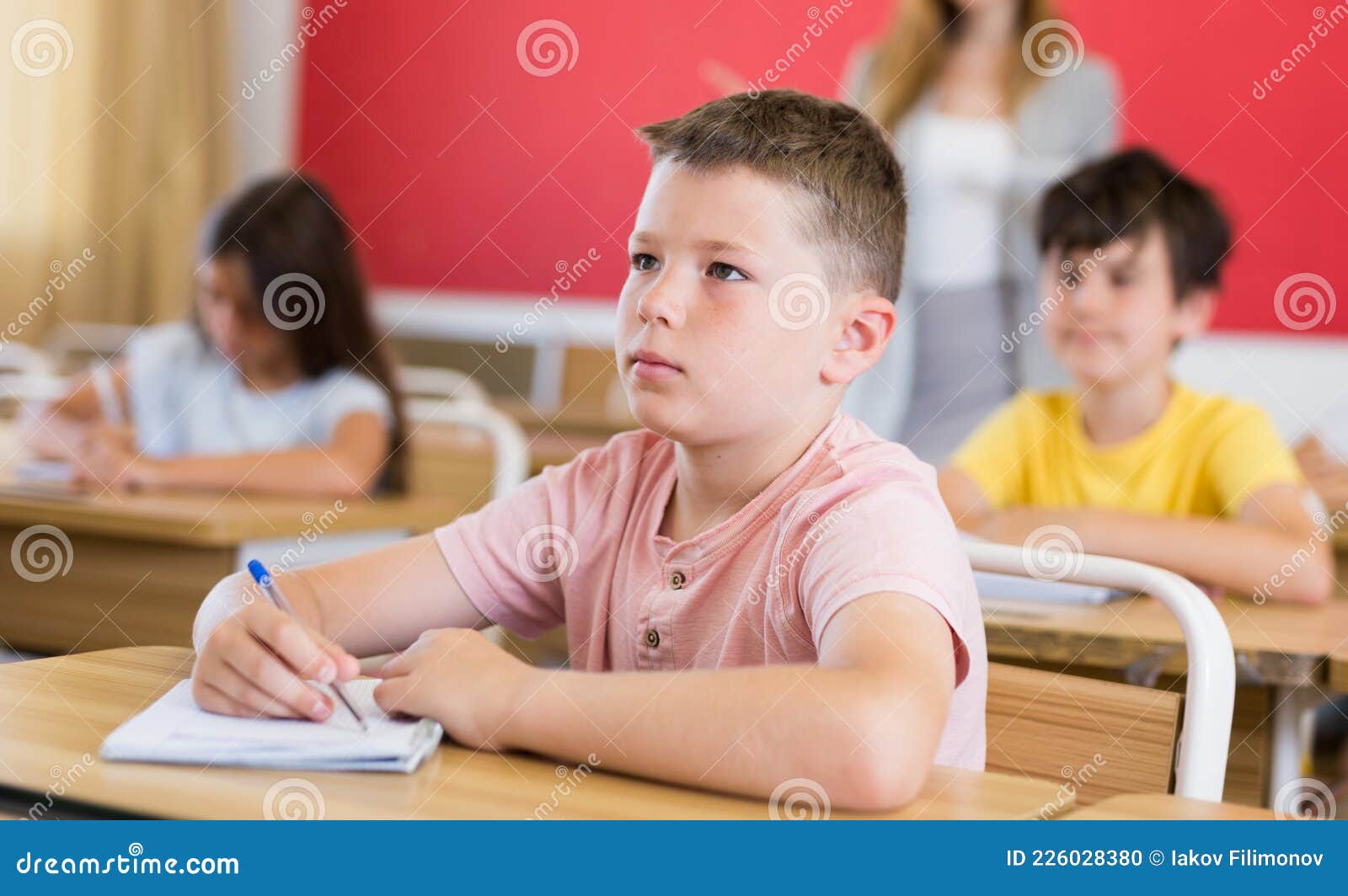 Crianças do ensino fundamental em uma sala de aula jogando futebol de mesa.  diversão durante o recreio na escola.