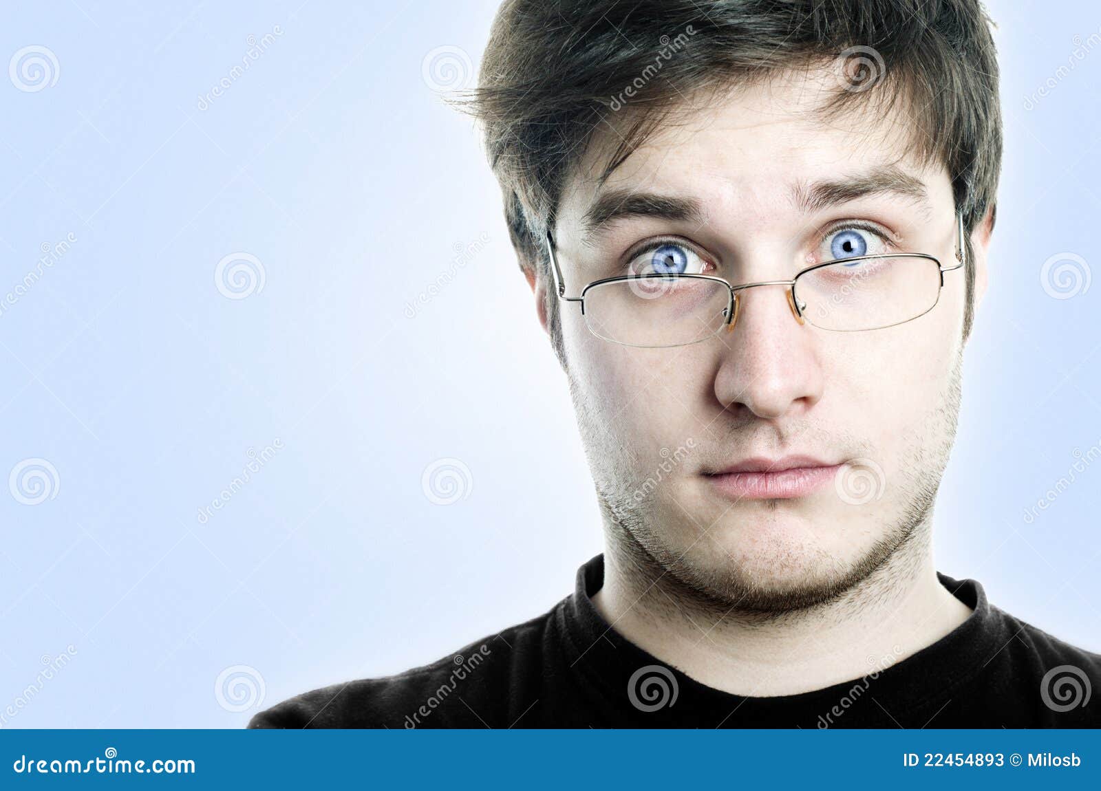 Estudiante con los vidrios. Retrato del estudiante de ojos azules con los vidrios. con el camino de recortes. Grano agregado al fondo.