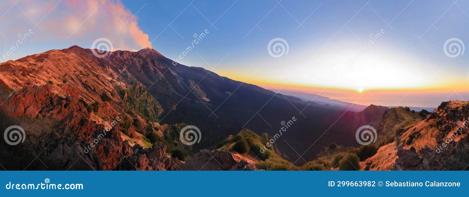 etna panoramica all'alba con vista sul cratere e valle del bove con sole che sorge e luci suggestive