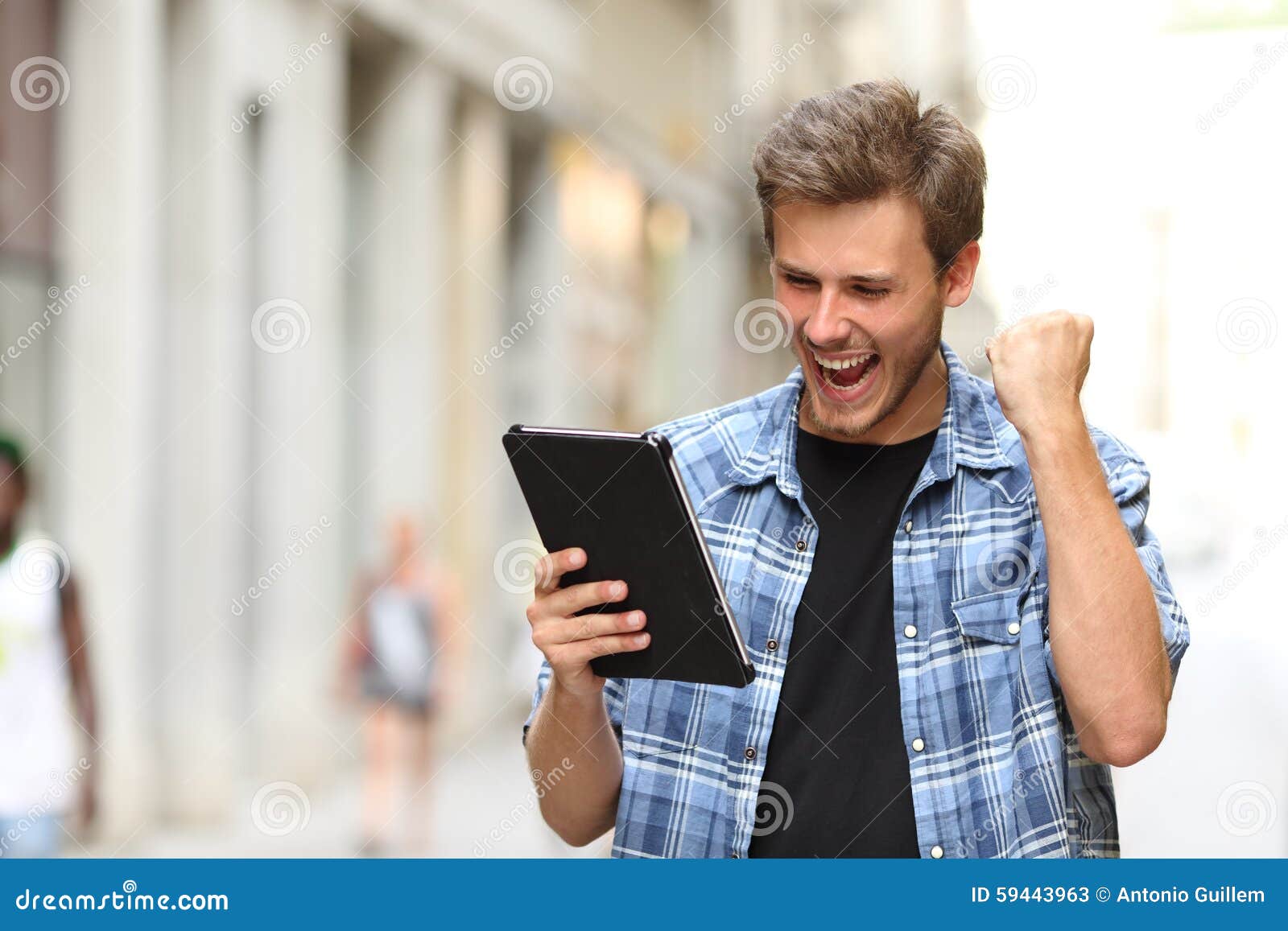 euphoric winner man with a tablet