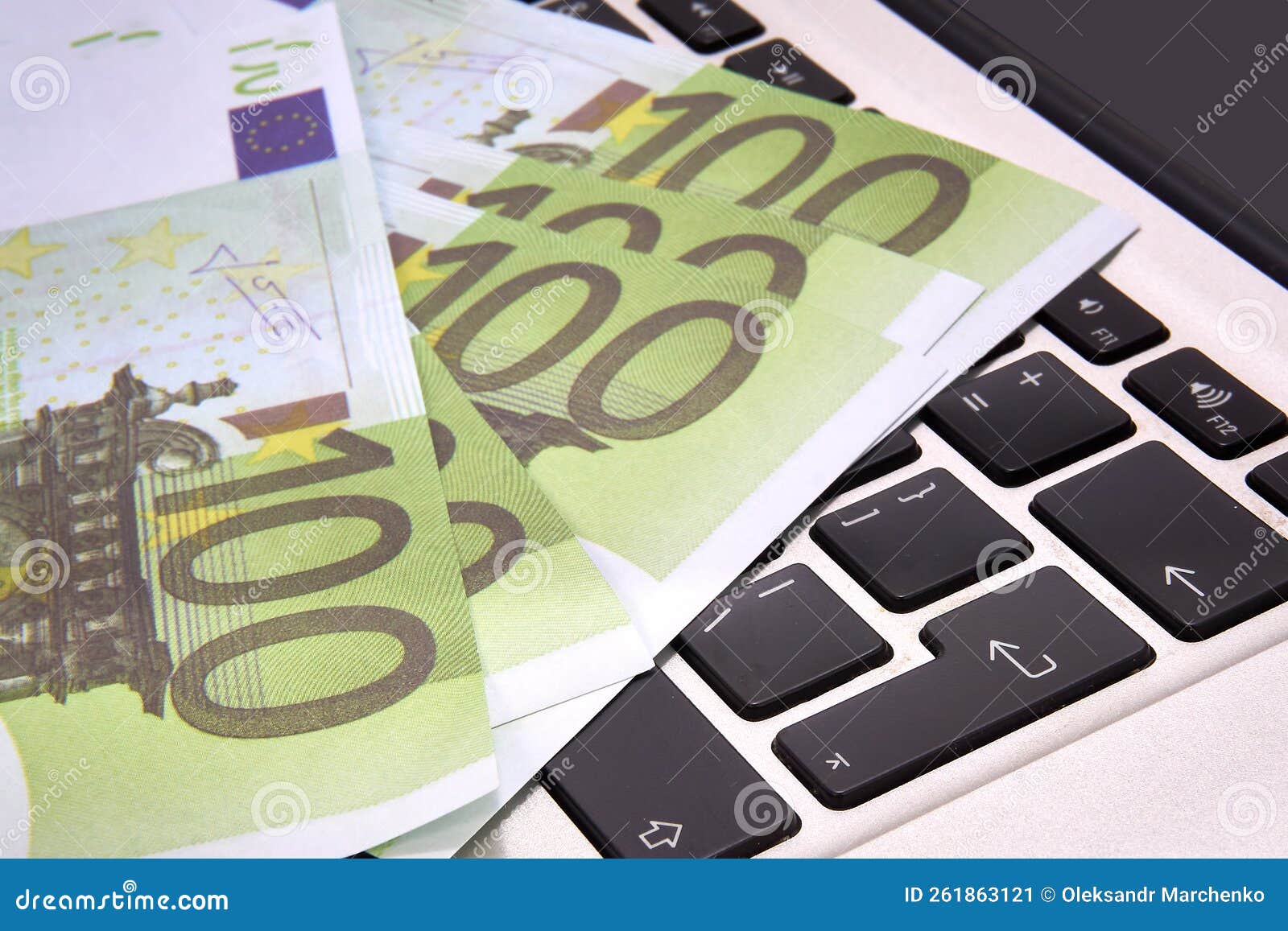 100 euro bills lying on a computer keyboard, close-up.