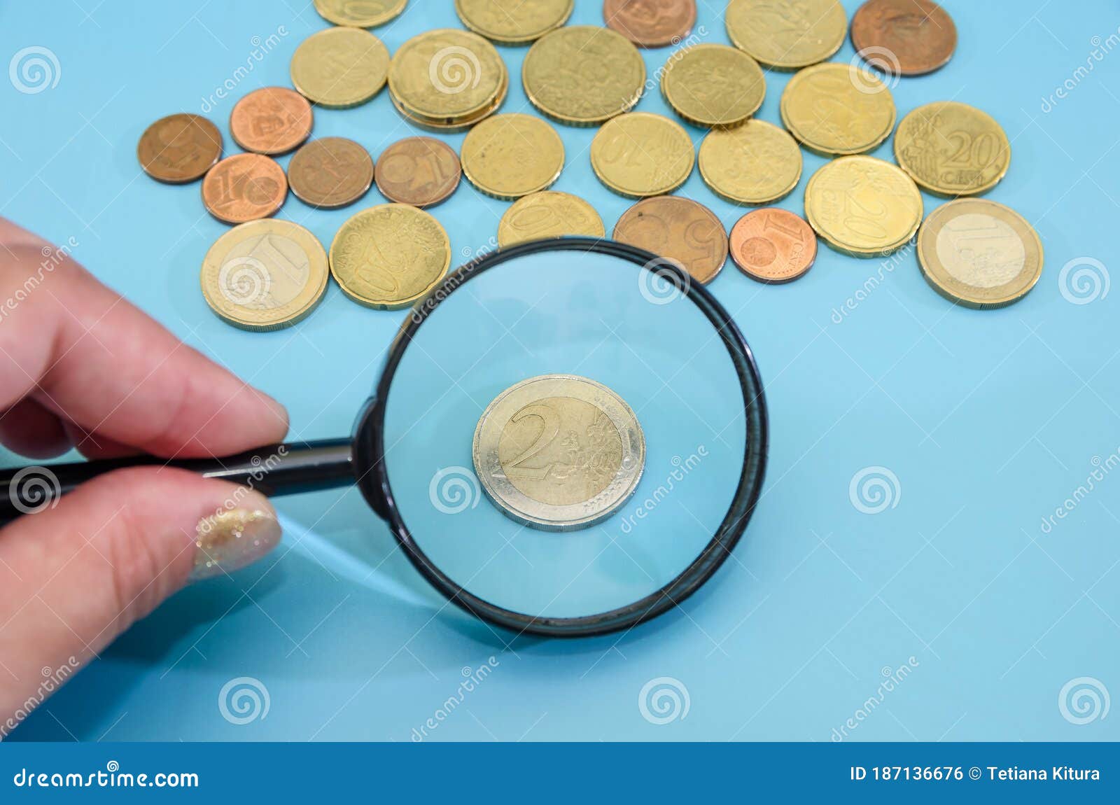 2 Euro Coin through a Magnifying Glass. Blue Background. Financial Concept.  Lots of Coins. Savings Concept. Stock Photo - Image of bank, economy:  187136676