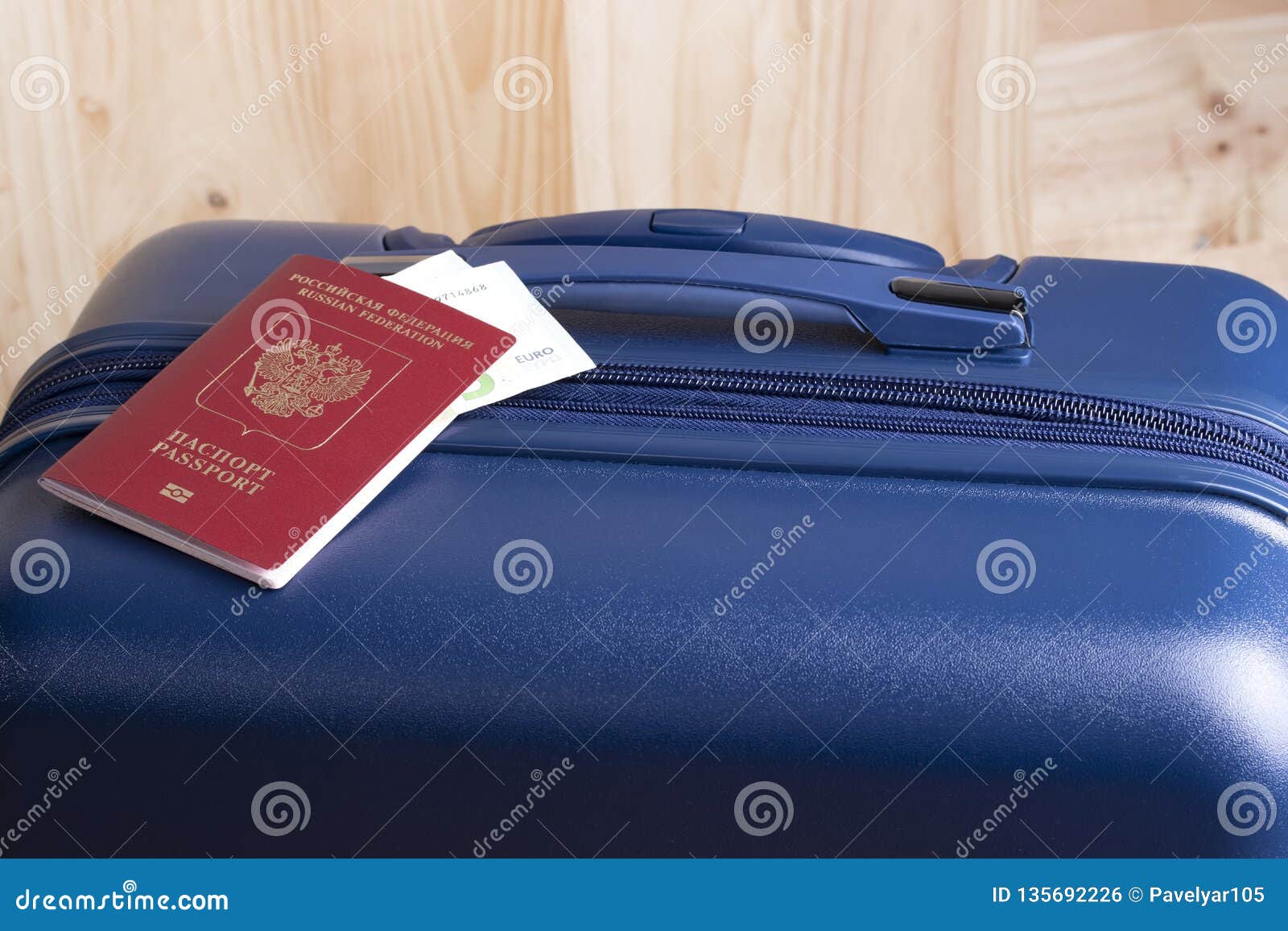 Euro and Russian international passport with a blue suitcase, ready for a business or holiday trip abroad