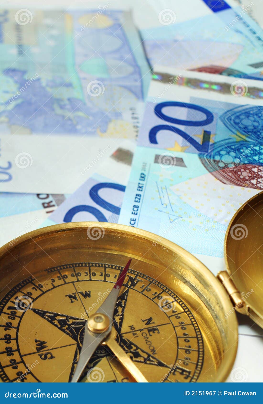 Eurobargeld auf Kurs 2. Ein Kompaß, seine Nadel, die Norden, auf einem Stapel von 20 Euroanmerkungen, eine Entscheidung der guten Investition oder etwas Finanzerfolg symbolisierend anzeigt.