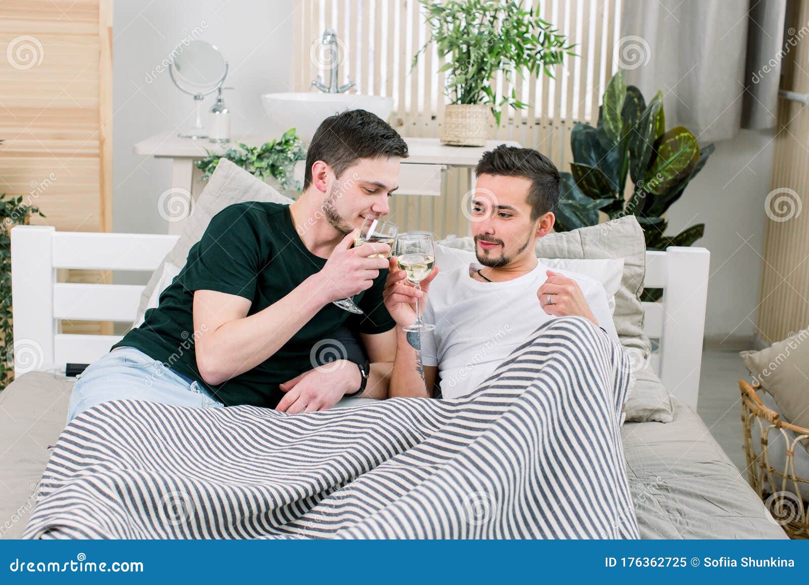 European Happy Gay Couple Drinking Wine While Having Fun In Bed Caressing Homosexual