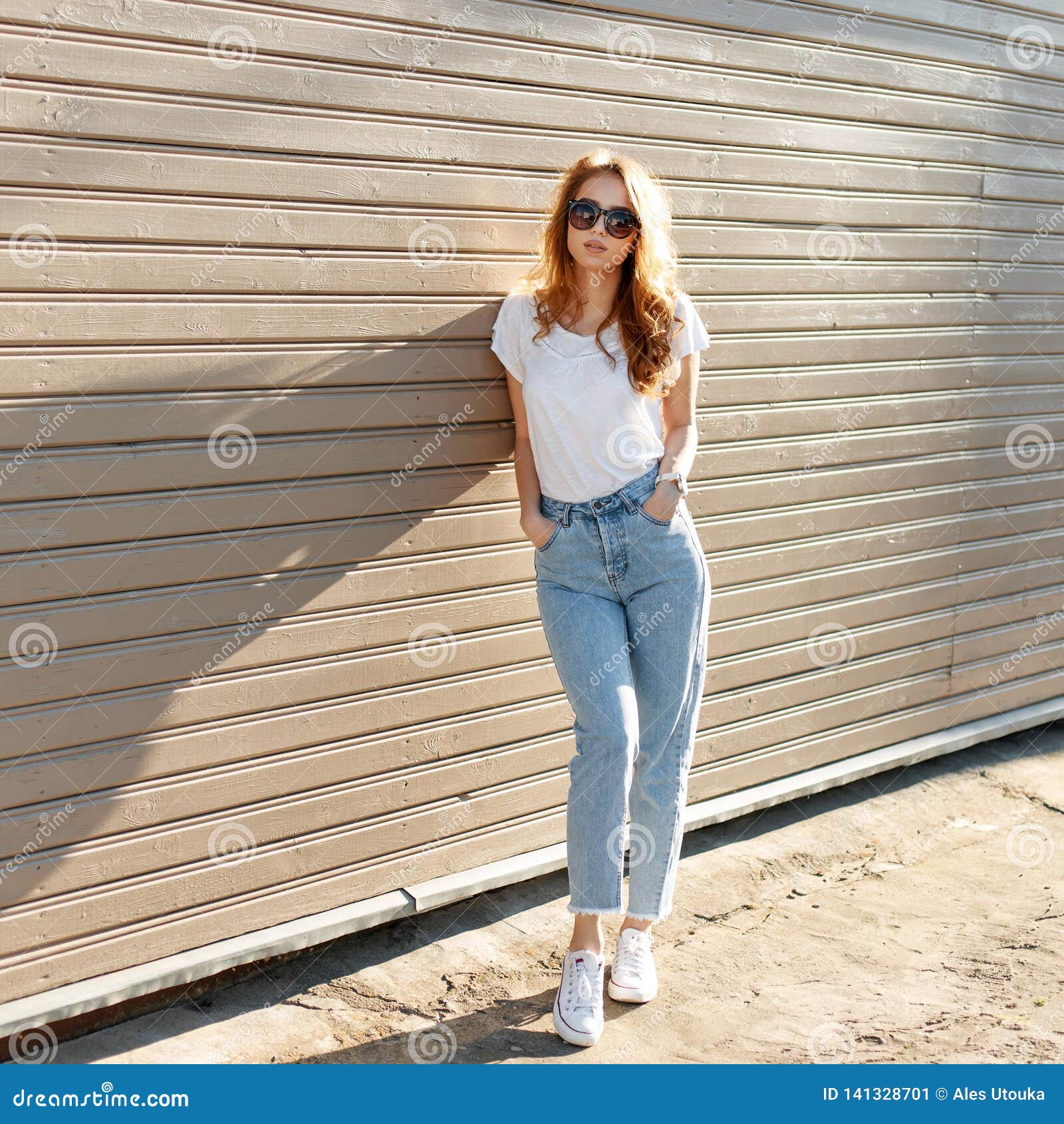European Pretty Young Hipster Woman In Stylish White T Shirt In Vintage Jeans In Trendy Sunglasses Is Standing Stock Image Image Of Blonde Girl