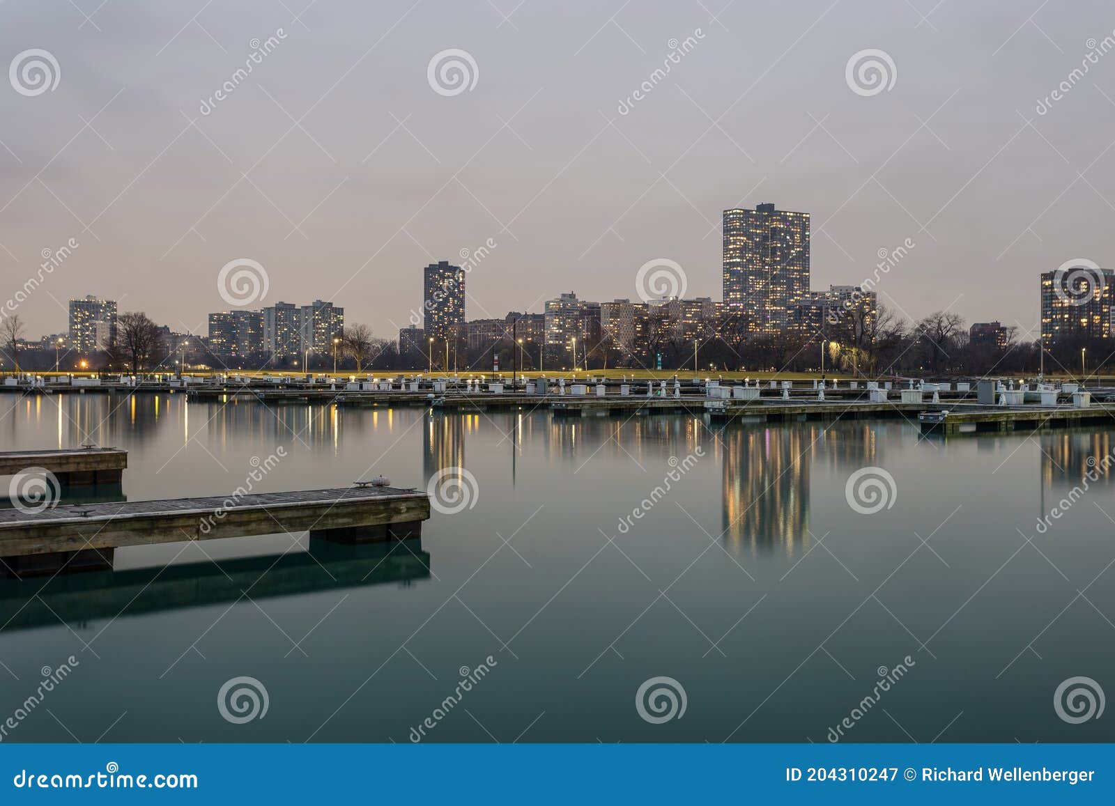 evening lighting over calm water with empty boat docks and apartment highrises