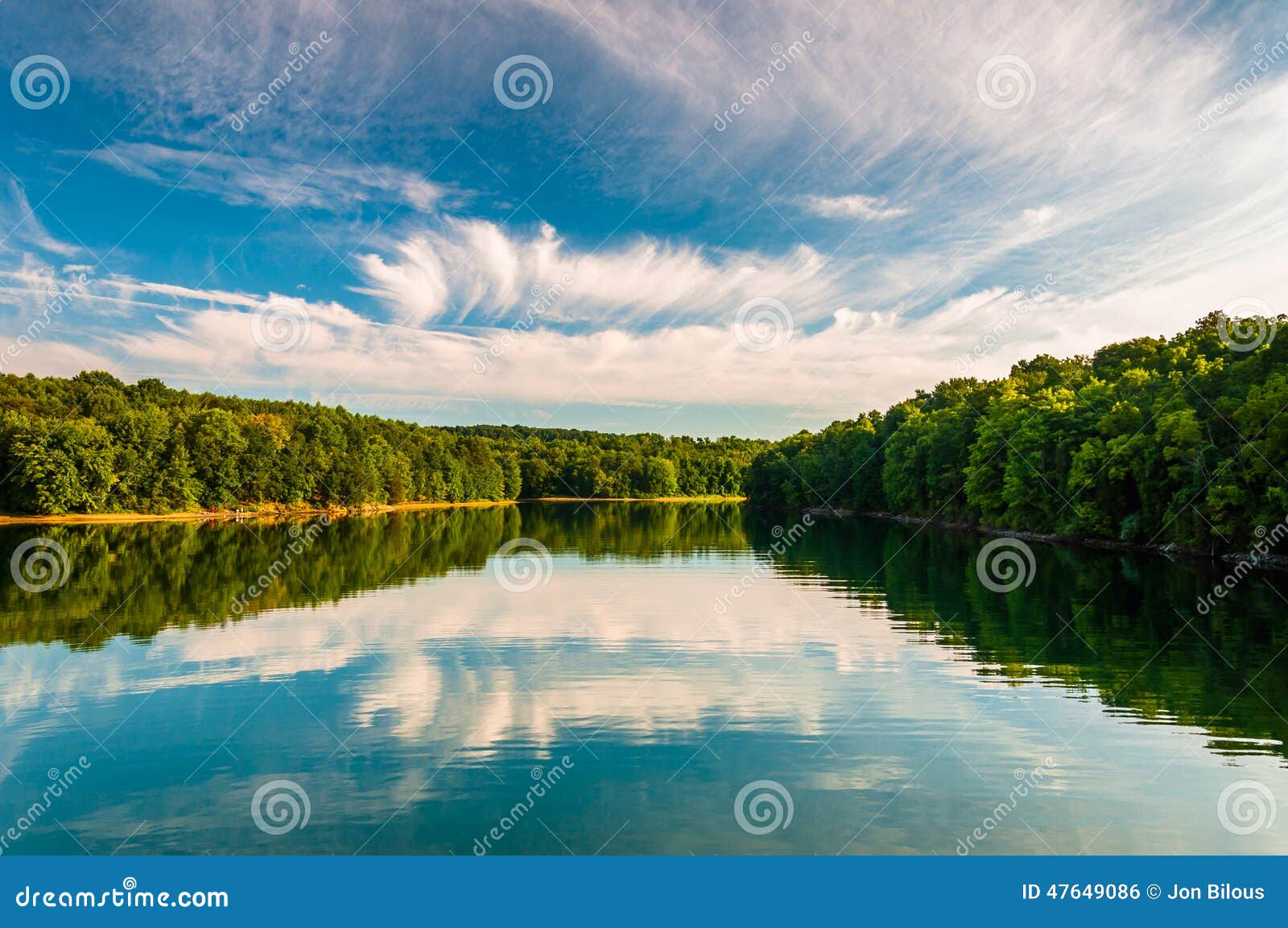 evening reflections of clouds and trees in lake marburg, codorus state park, pennsylvania.