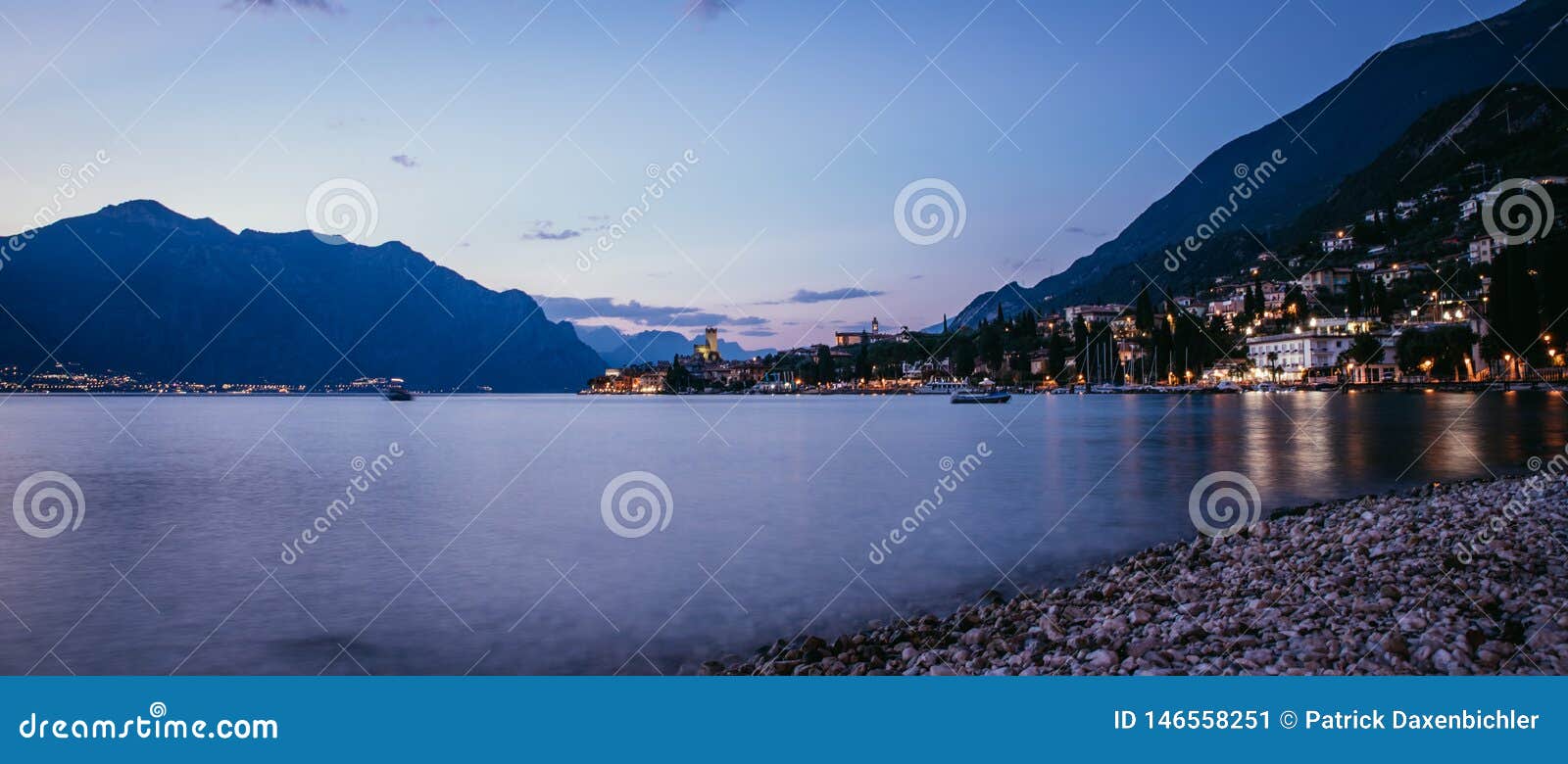 evening scene at lago di garda: beach, lake and village, panorama