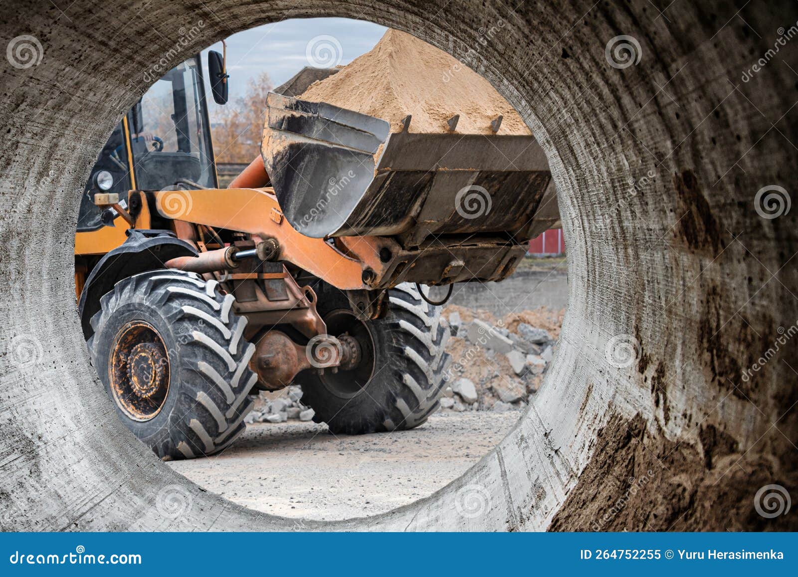 the excavator backfills the pit with the front bucket. moves soil around the construction site. close-up. heavy construction