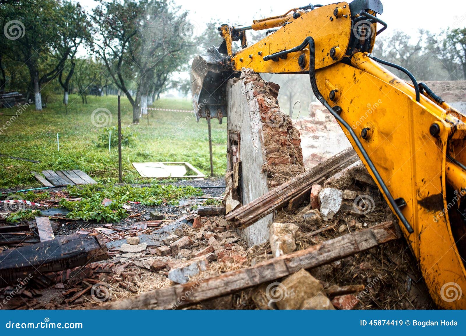 excavator demolishing a concrete wall