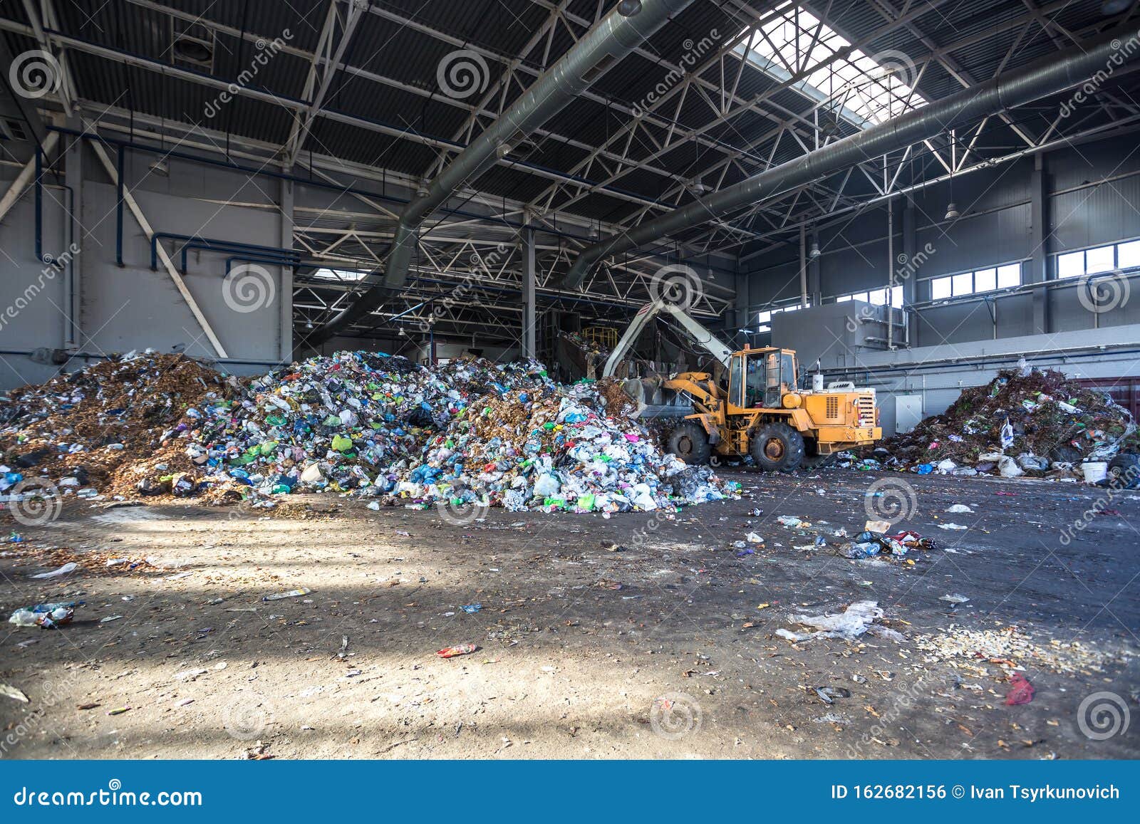 excavator stacks trash in big pile at sorting modern waste recycling processing plant. separate and sorting garbage collection.