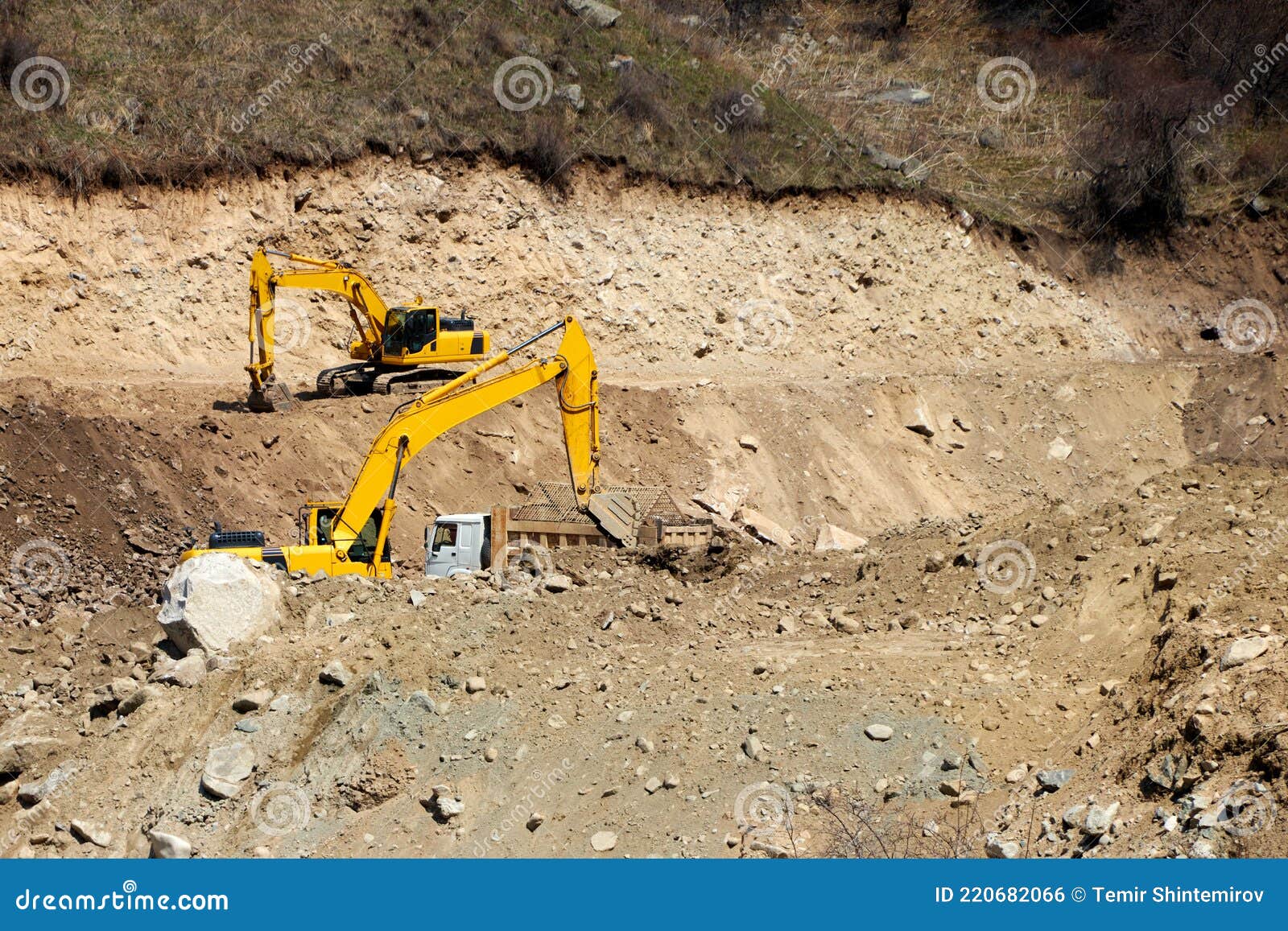 Excavators Digging the Rocky Bank of a Mountain River Stock Photo