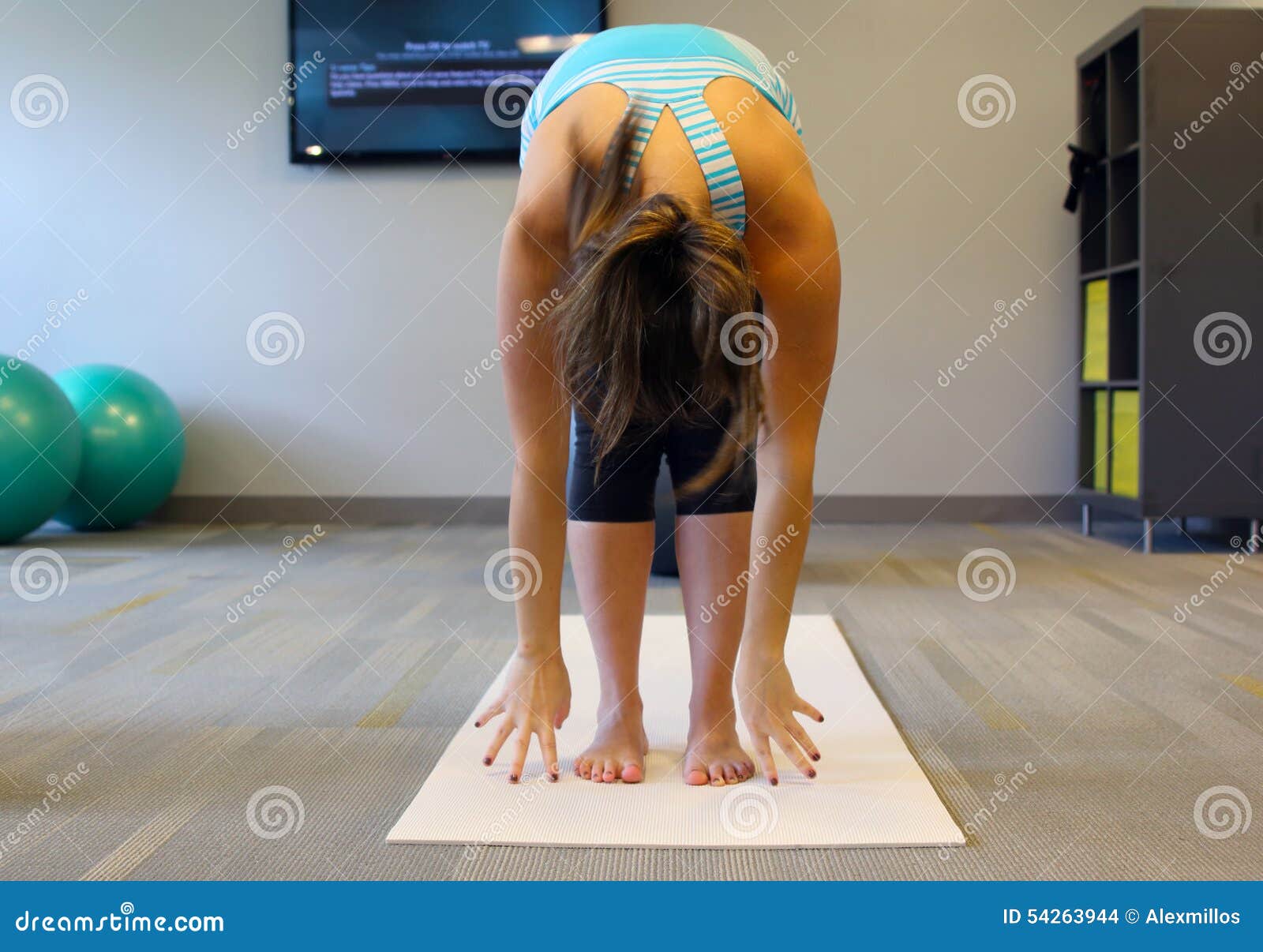 Excersise femenino de la yoga en una estera blanca Estudio del gimnasio