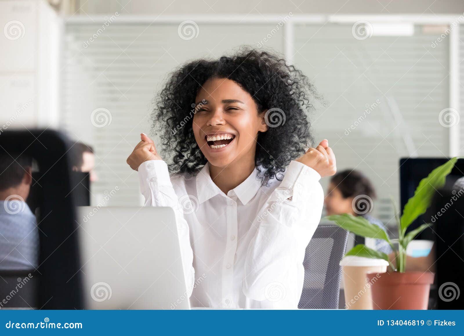 excited african american woman receiving good news on laptop