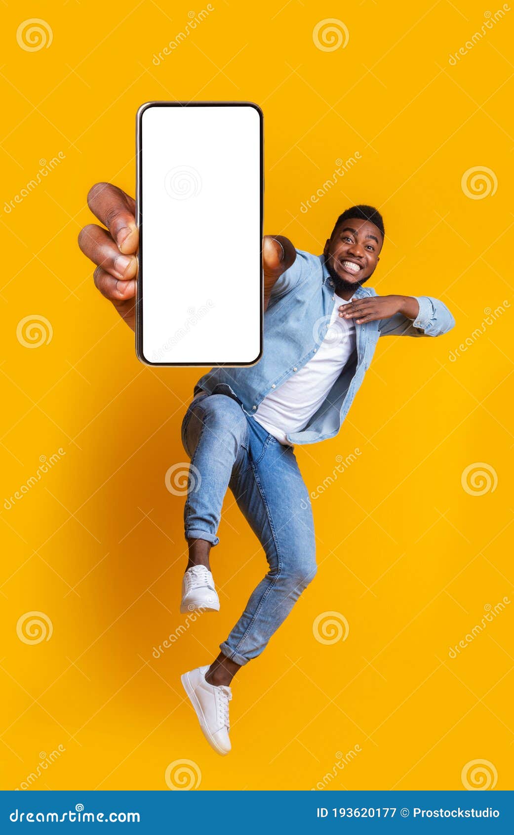 excited african guy dancing with modern smartphone