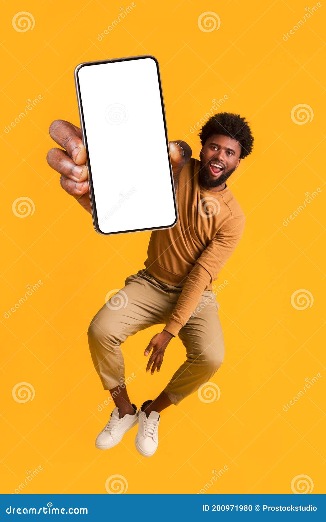 excited black guy holding smartphone, jumping up